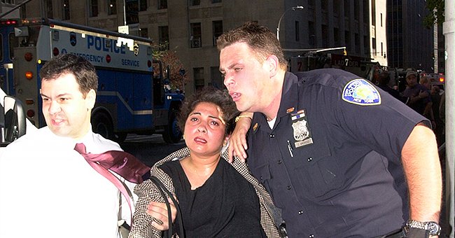 Police officer helps a woman get away from the dangerous events unfolding during the 9/11 terror attacks | Photo: Twitter/PAPD911 & Getty Images