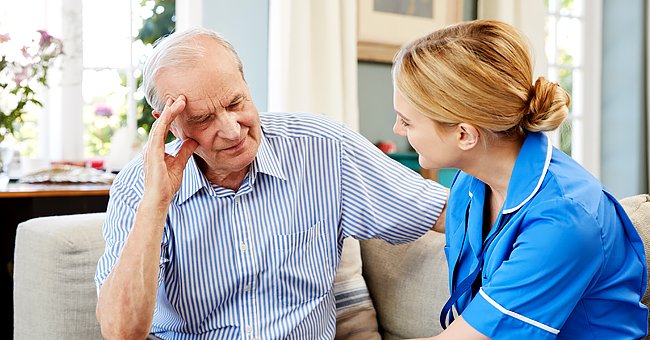 Eine Krankenschwester, die sich um einen älteren Mann im Krankenhaus kümmert. | Quelle: Shutterstock