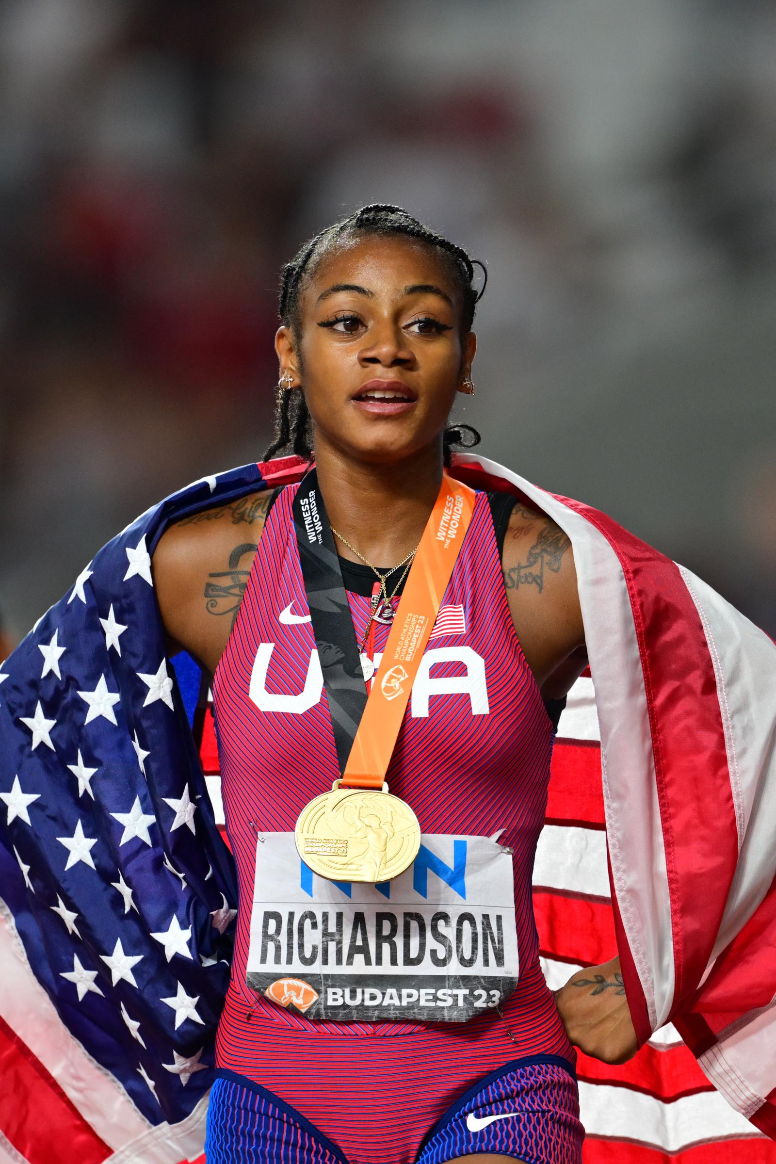 Sha'Carri Richardson poses with her gold medal after winning the women's 100m final during the World Athletics Championships on August 21, 2023, in Budapest, Hungary. | Source: Getty Images