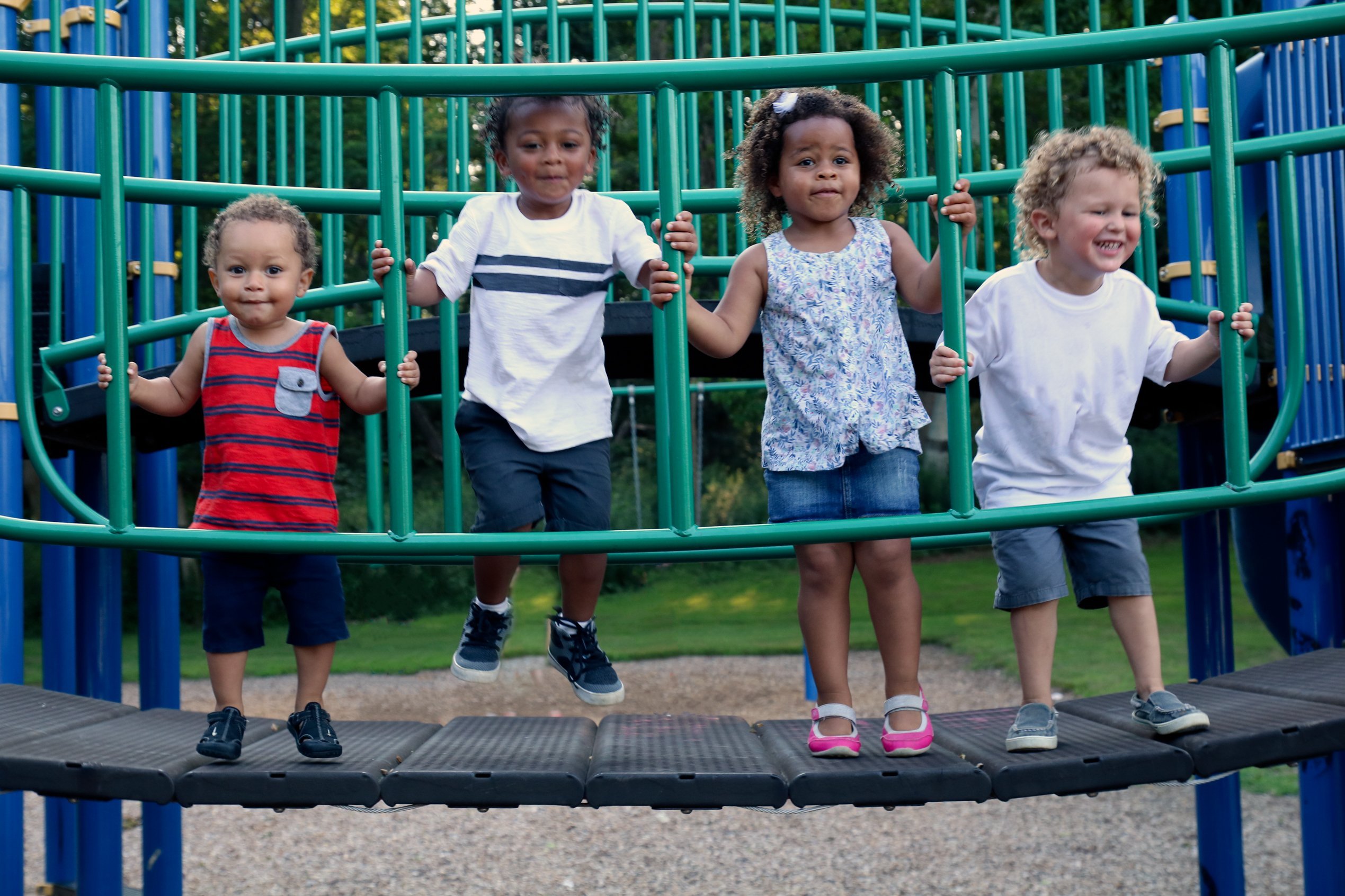 Diverse group of four children are playing together at the park. | Photo: Shutterstock