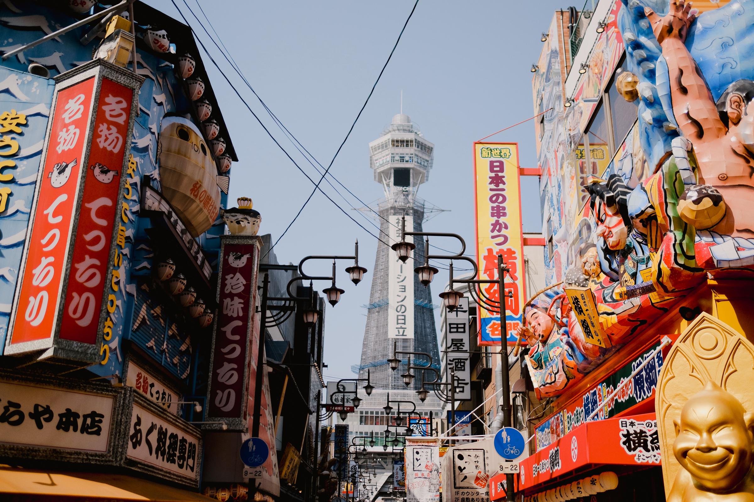 A busy street in Osaka, Japan, with the iconic Tsutenkaku Tower rising above the surrounding buildings. | Source: Pexels