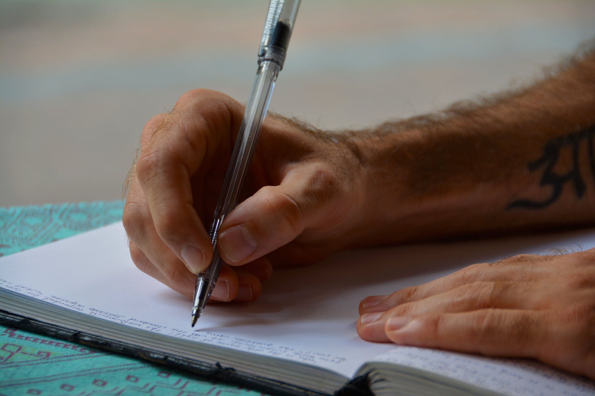 Man writing in a notebook | Source: Pexels