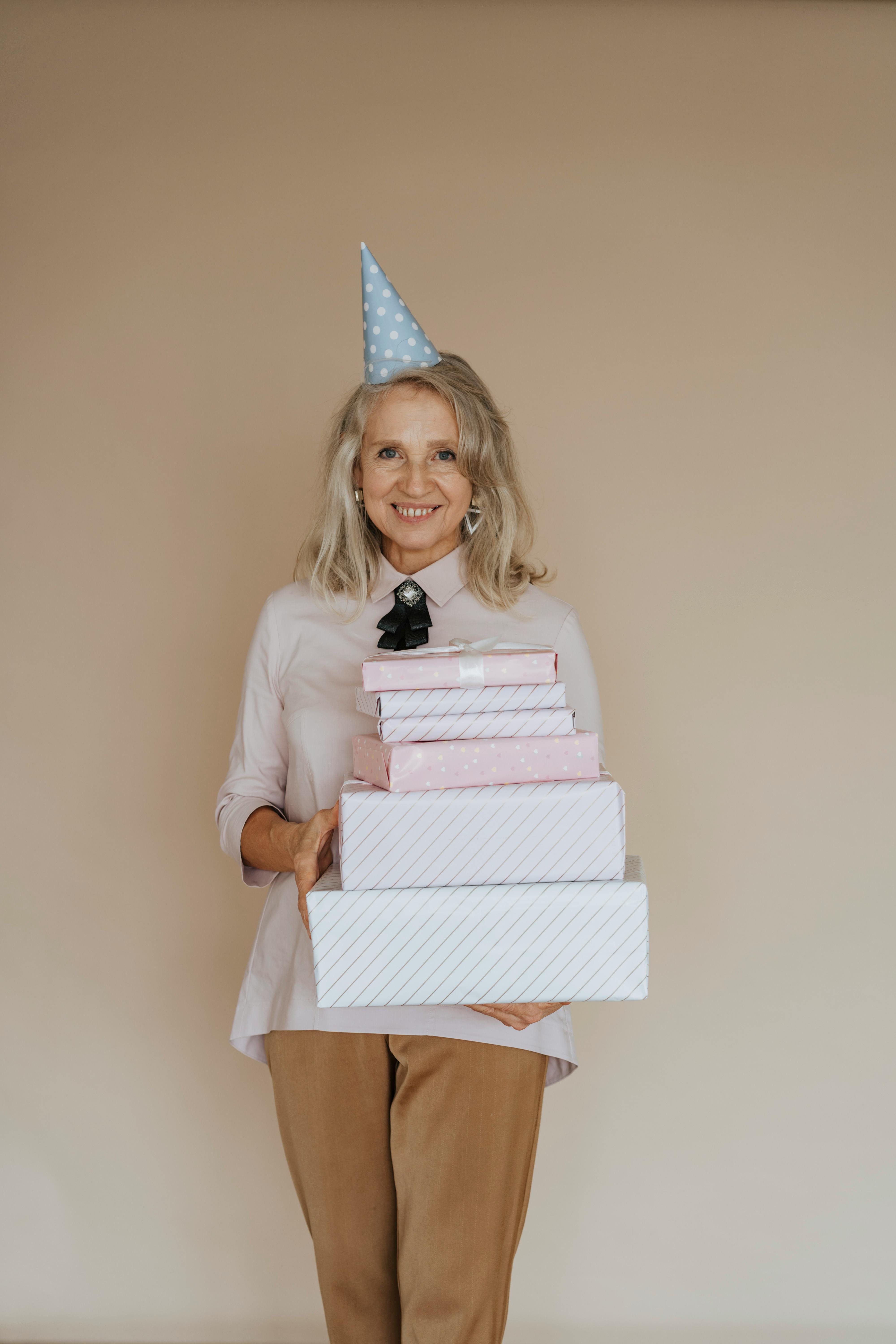 An older woman carrying a pile of gifts | Source: Pexels