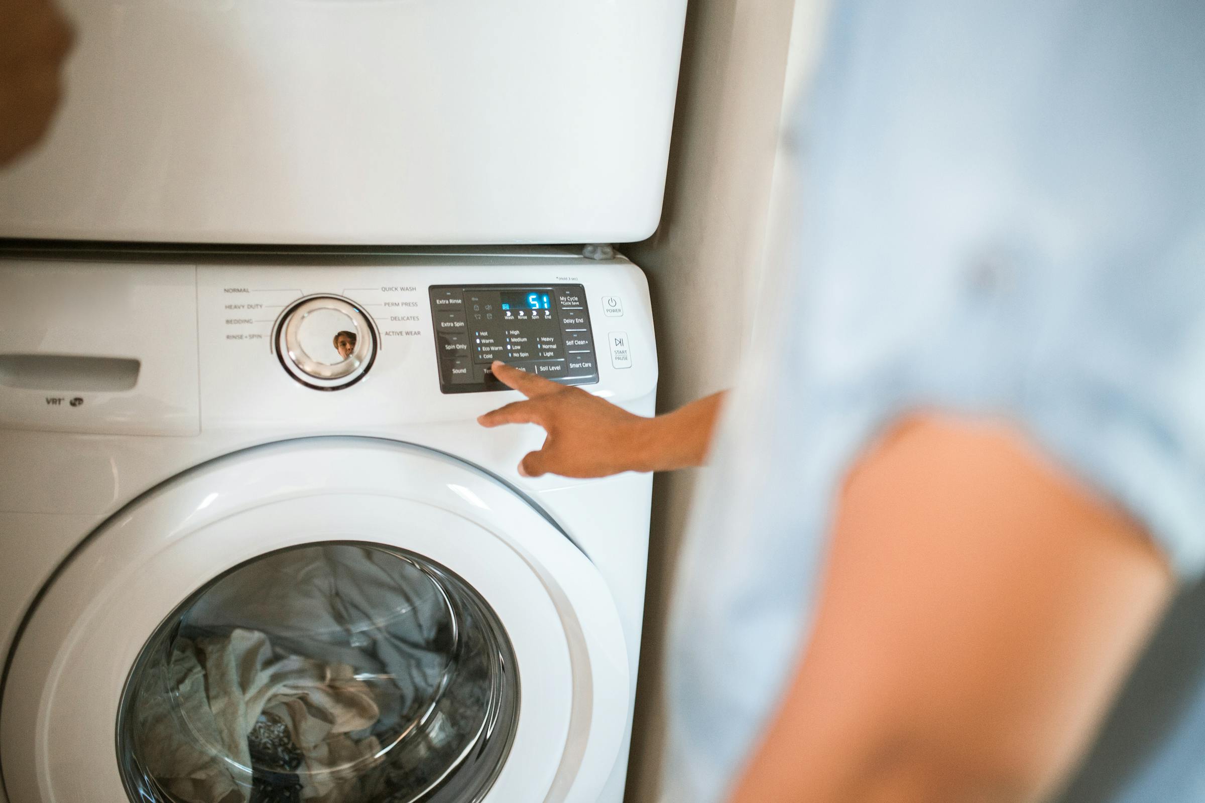 Man turning on a washing machine | Source: Pexels