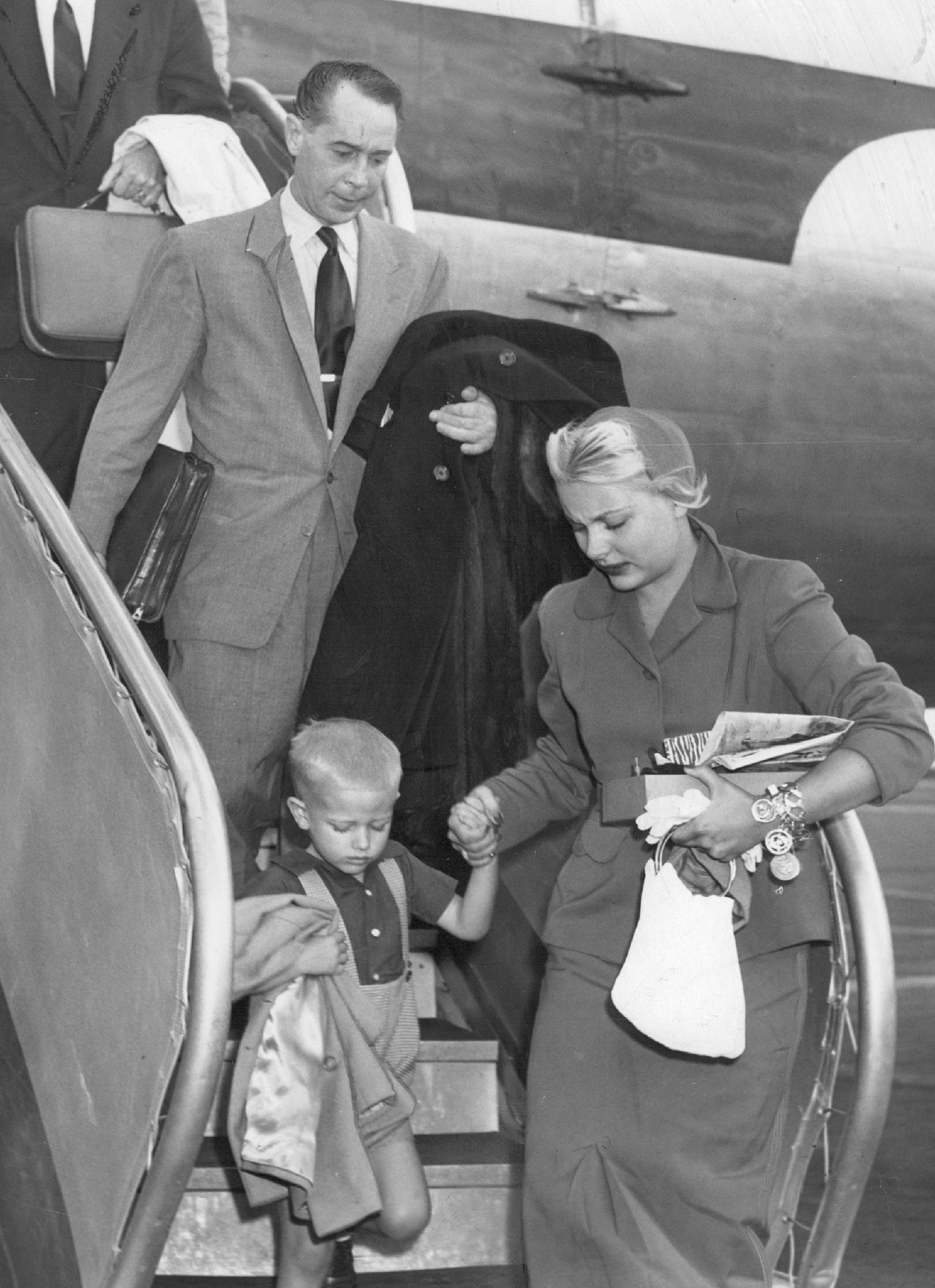 Franchot Tone, Barbara Payton, and her son Johnny Payton getting off a plane in October, 1951 | Photo: Getty Images 