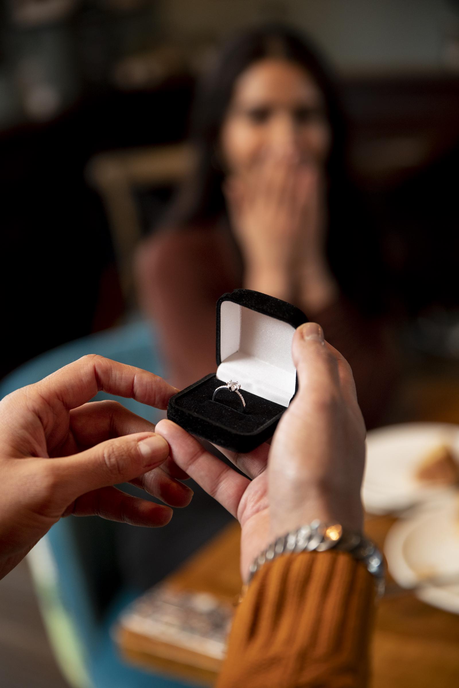 Close-up of a man holding a small velvet box with a diamond ring | | Source: Freepik