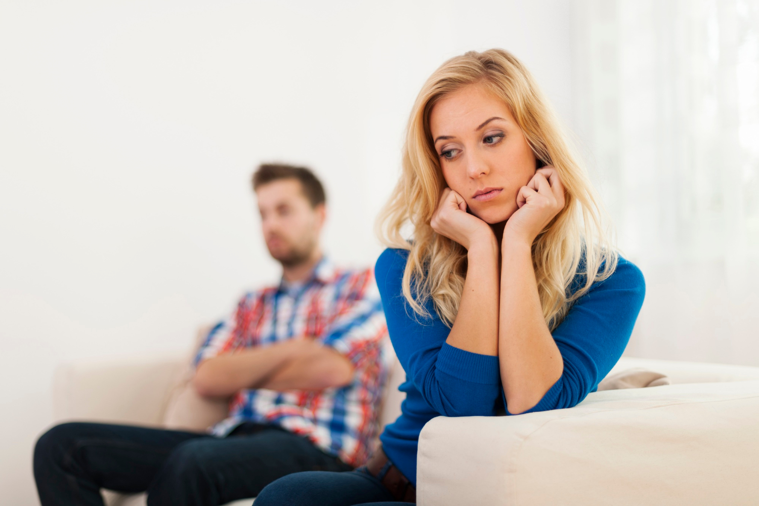 A distressed couple sitting on the couch | Source: Freepik