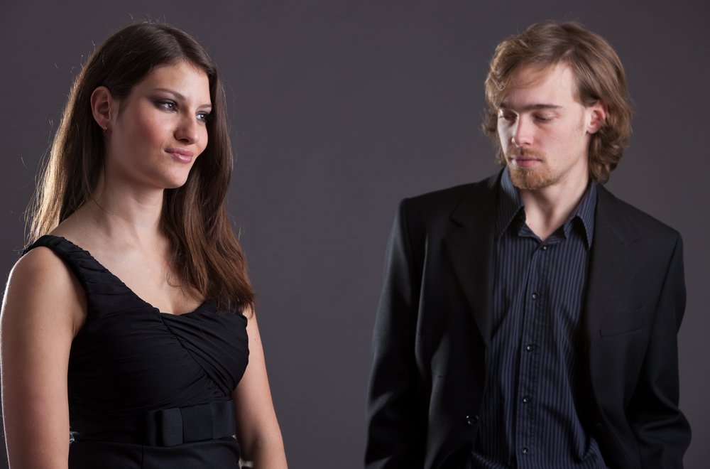 A man looking at a lady who seems uninterested in him.| Photo: Shuterstock.