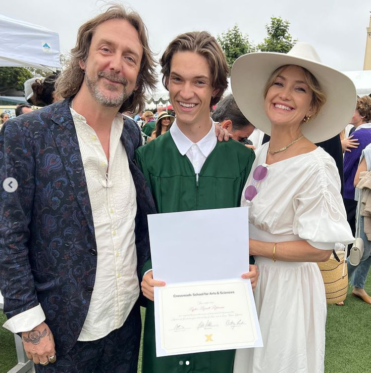 Ryder Robinson proudly smiles at his high school graduation ceremony alongside his parents Chris Robinson and Kate Hudson, June 2022. | Source: Instagram/katehudson