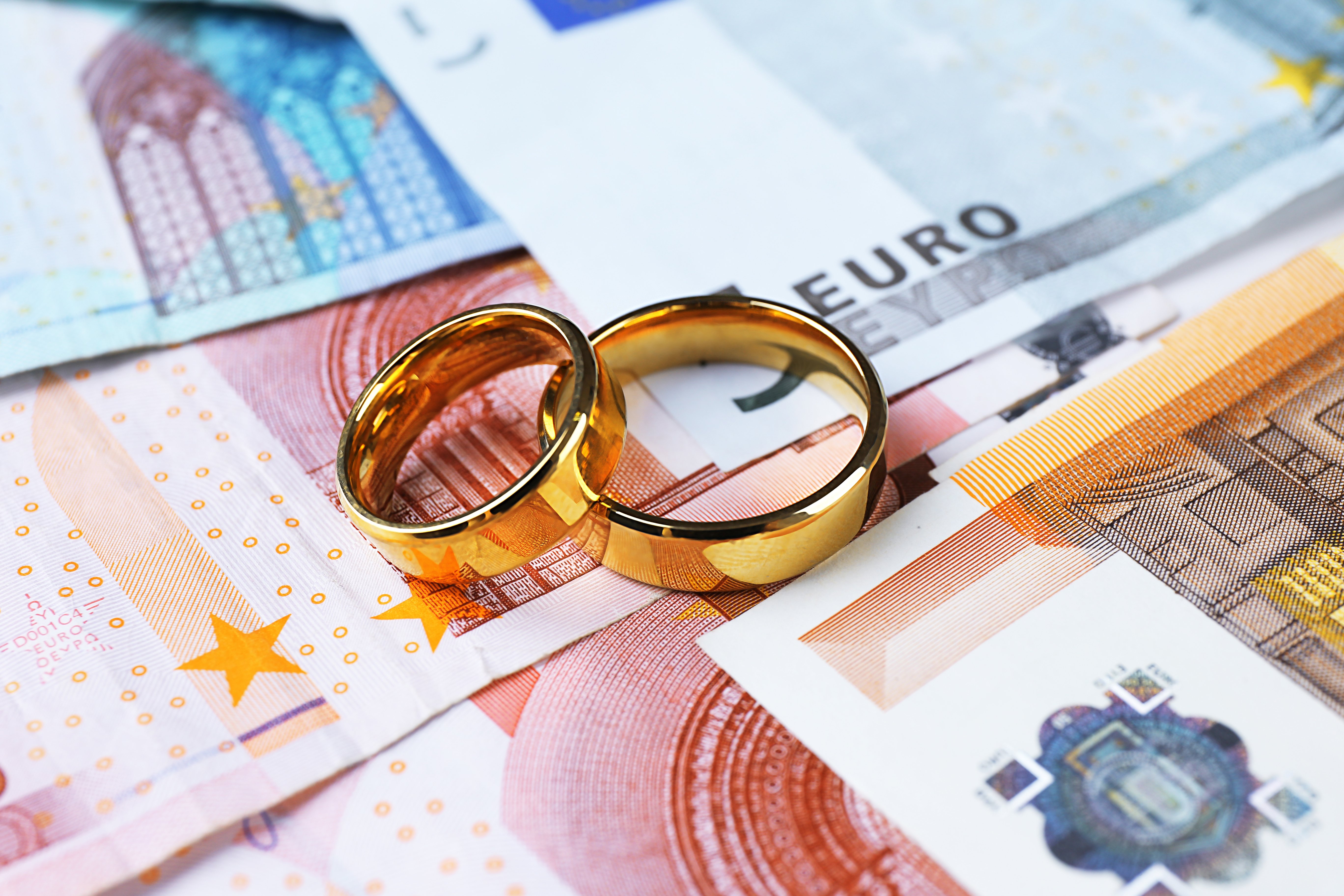 Anillos de compromiso sobre dinero en efectivo. | Foto: Shutterstock