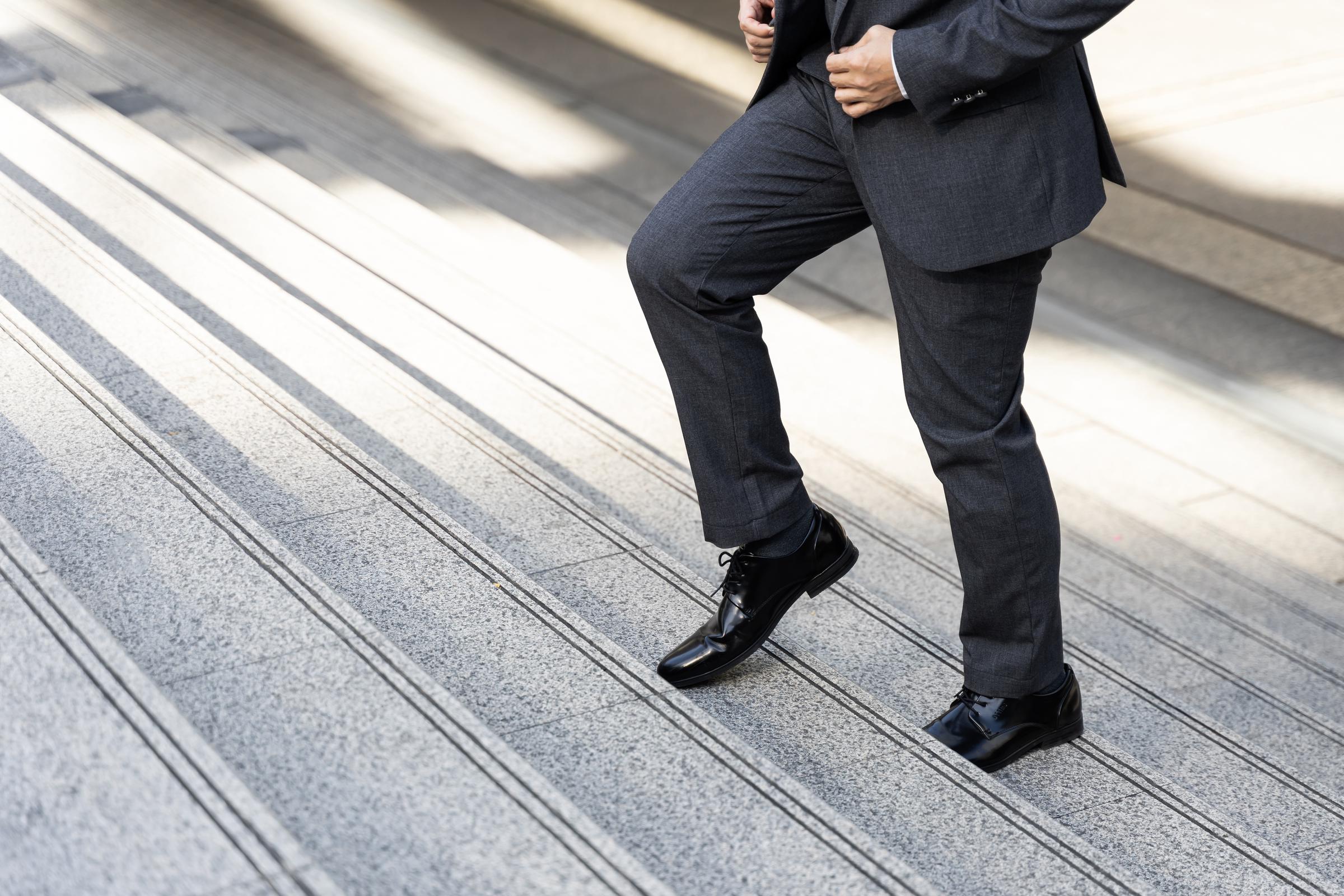 Man in suit hurrying upstairs | Source: Freepik