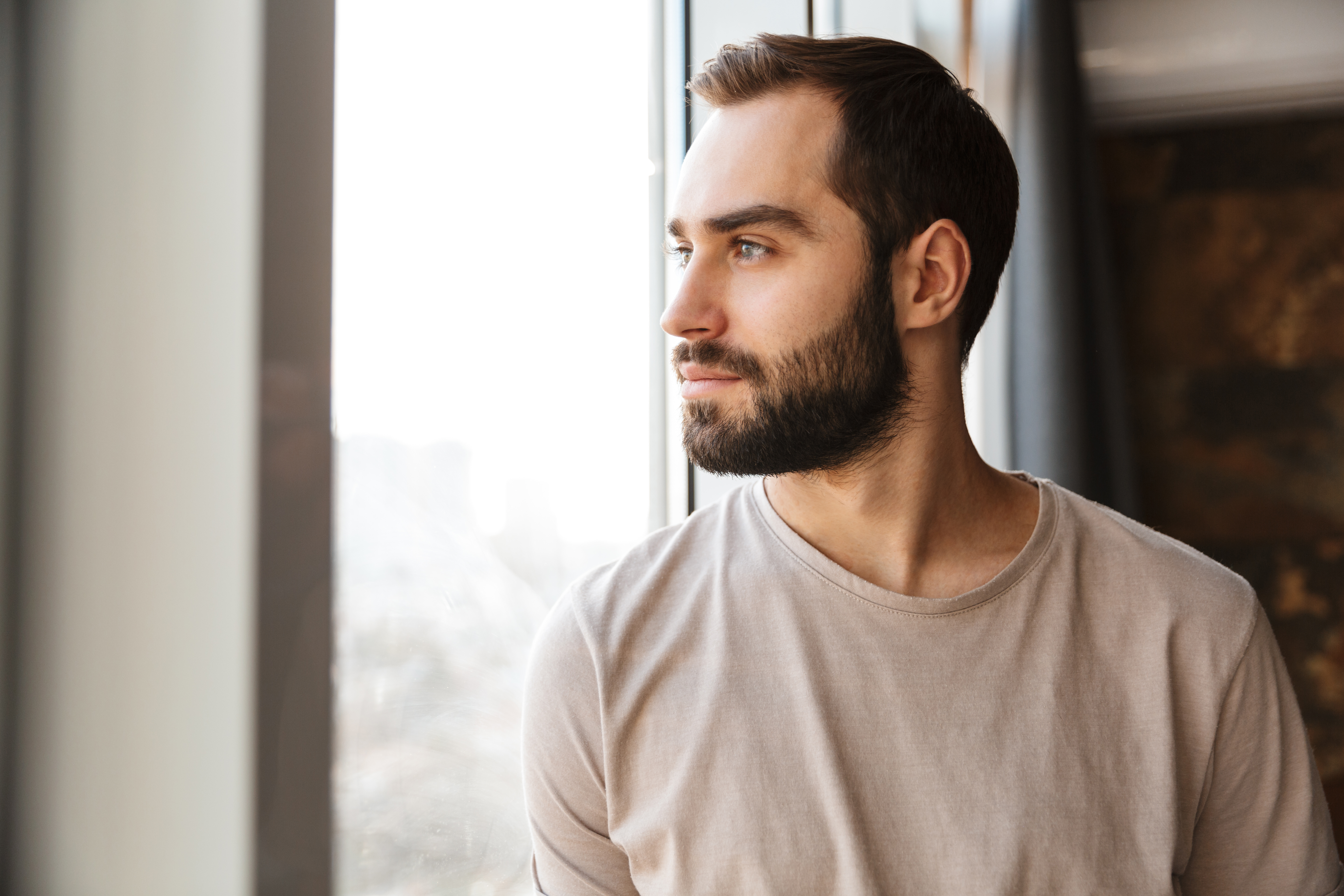 A man looking outside a window | Source: Shutterstock