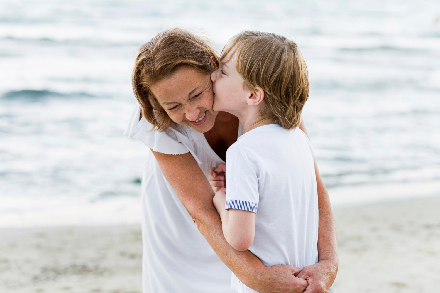 A little boy kissing his grandma | Source: Freepik