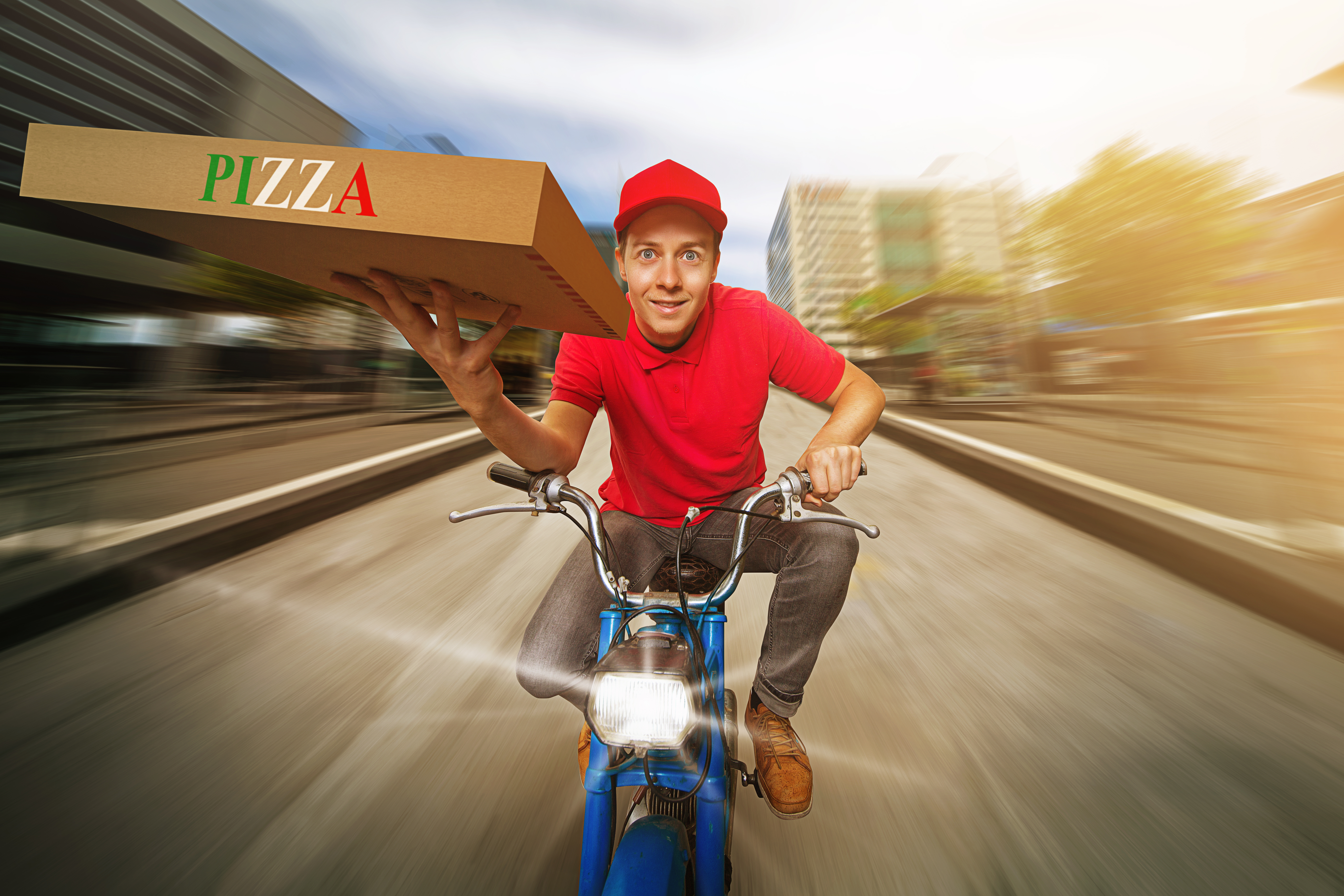 A pizza delivery driver speeding down a road | Source: Shutterstock