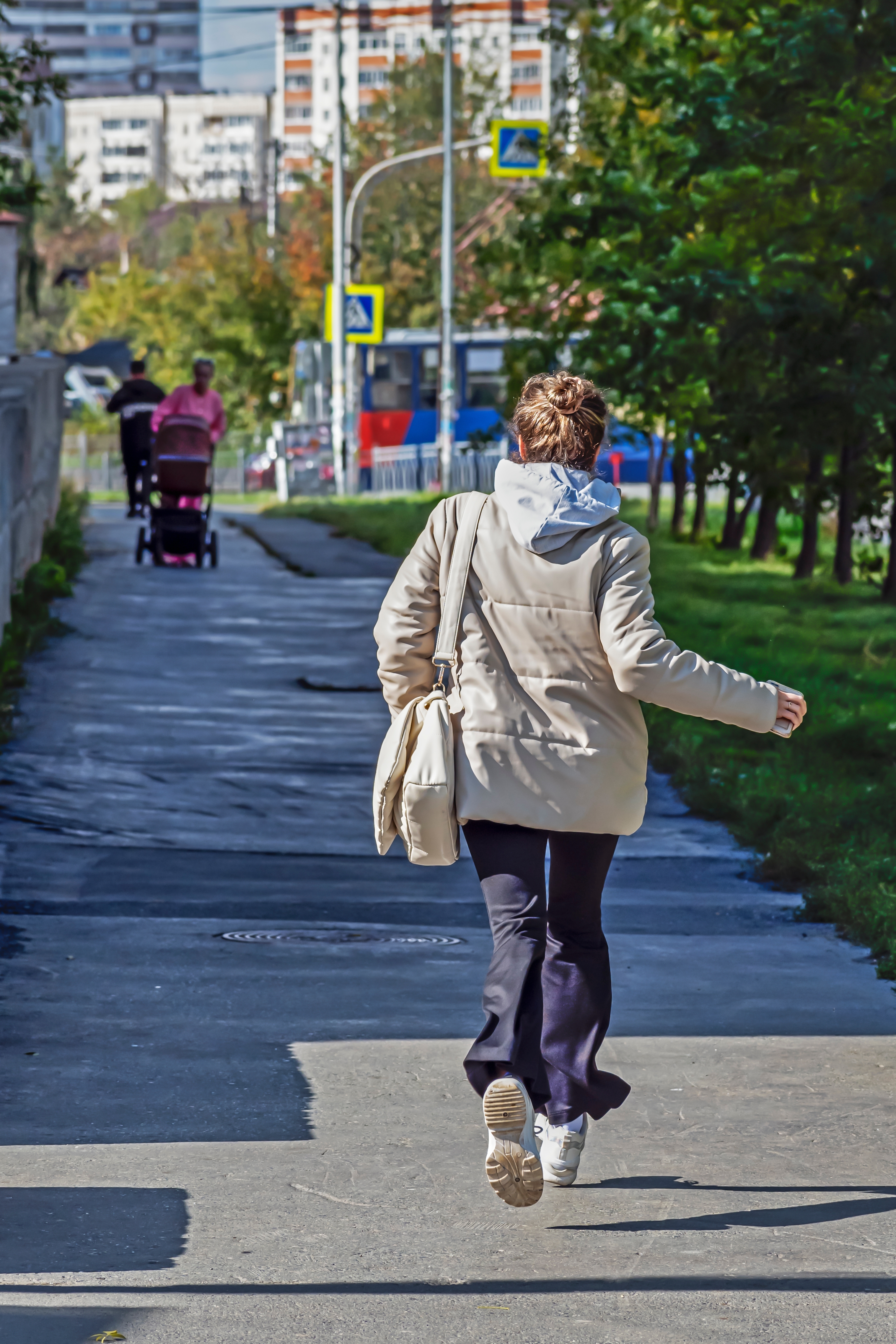 A woman runs along the sidewalk on an autumn day. | Source: Shutterstock