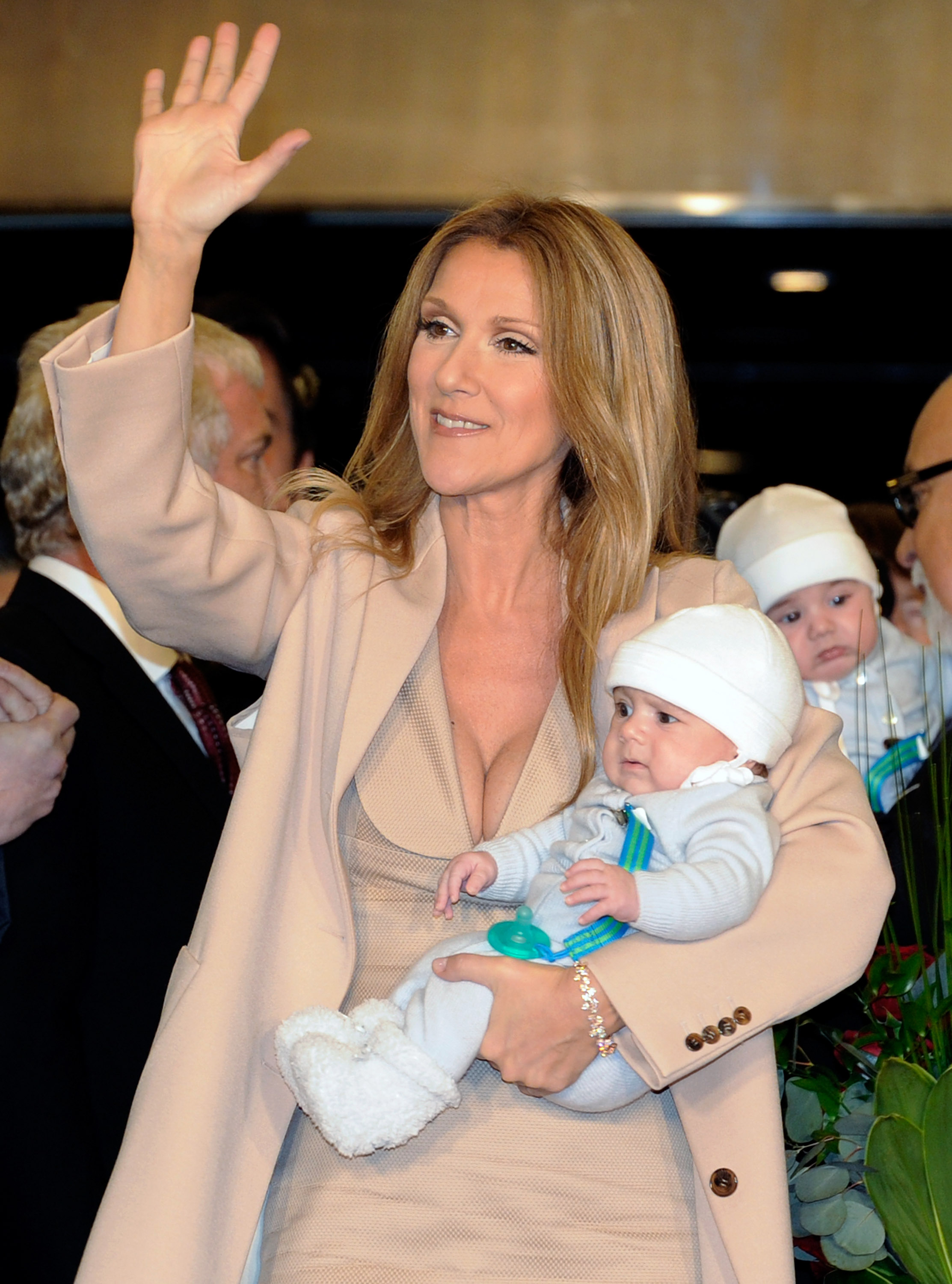 Celine Dion waves as she holds Nelson Angelil, with Eddy Angelil in the background, as she arrives at Caesars Palace in Las Vegas, Nevada, on February 16, 2011. | Source: Getty Images