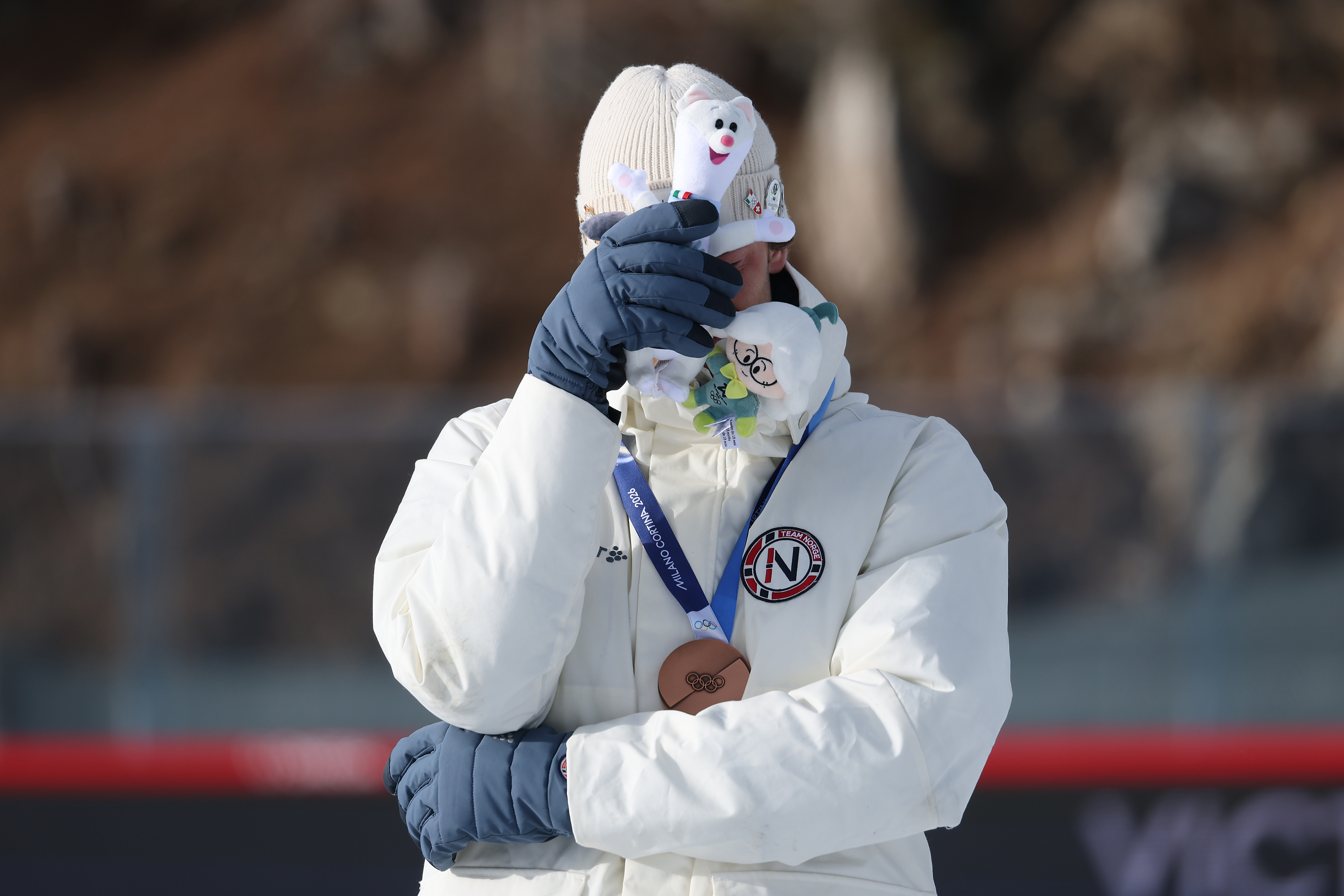 Sturla Holm Laegreid covers his face  on the podium during the men’s 20km individual medal ceremony at the Milano Cortina 2026 Winter Olympic Games in Italy on February 10. | Source: Getty Images
