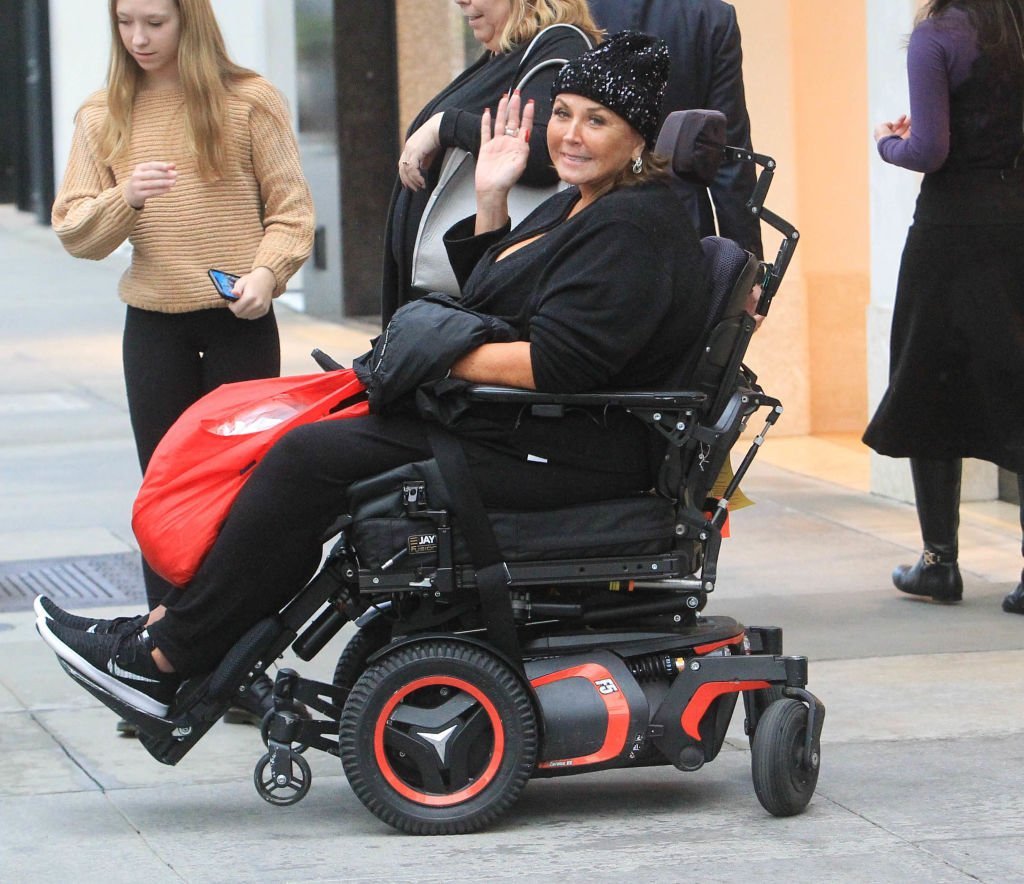 Abby Lee Miller waves from her wheel chair as she is pictured by paparazzi on December 4, 2019, in Los Angeles, California | Source: Getty Images (Photo by SMXRF/Star Max/GC Images)