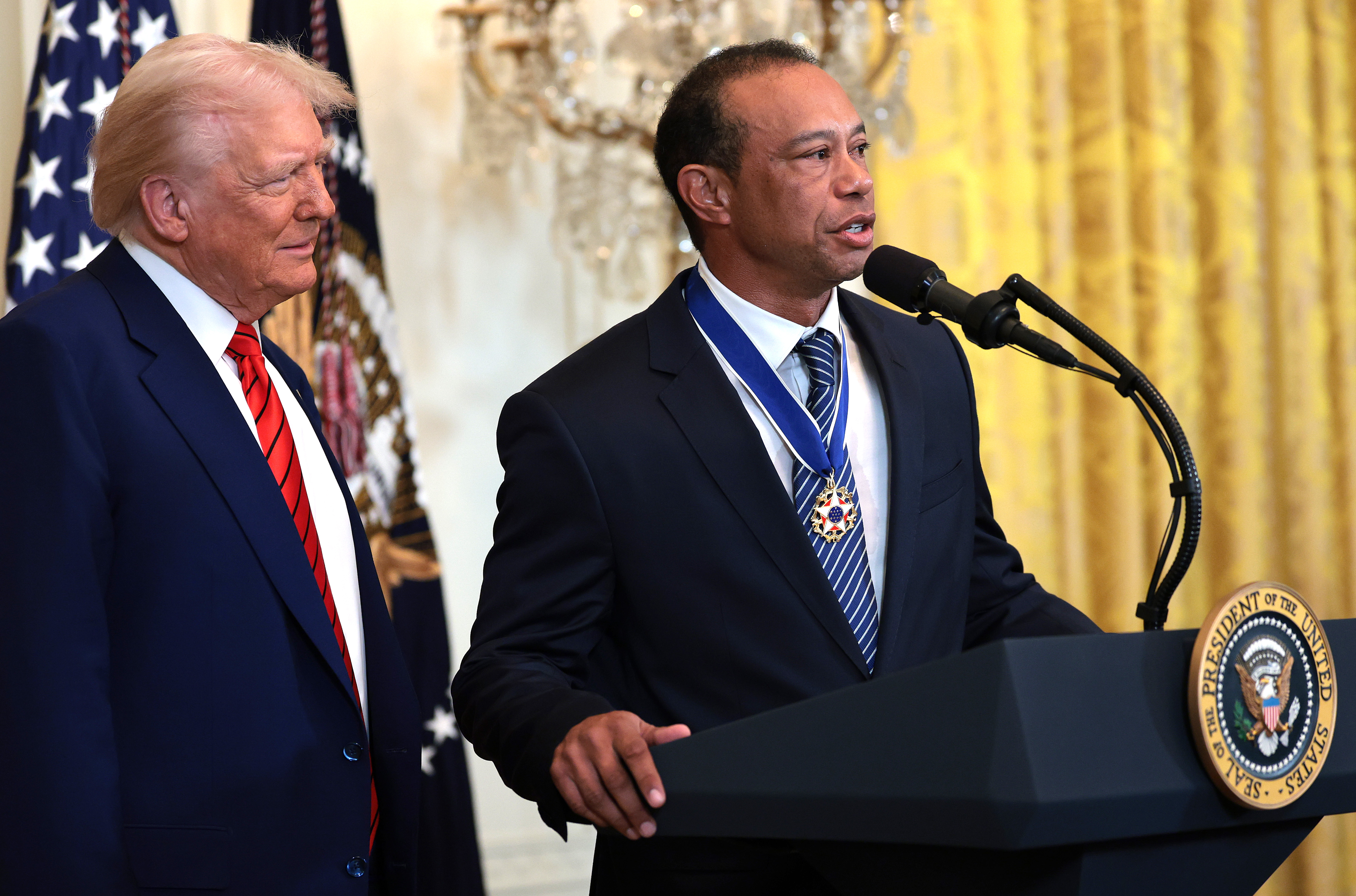 Tiger Woods speaks alongside President Donald Trump during a Black History Month reception in the East Room of the White House on February 20, 2025, in Washington, DC | Source: Getty Images