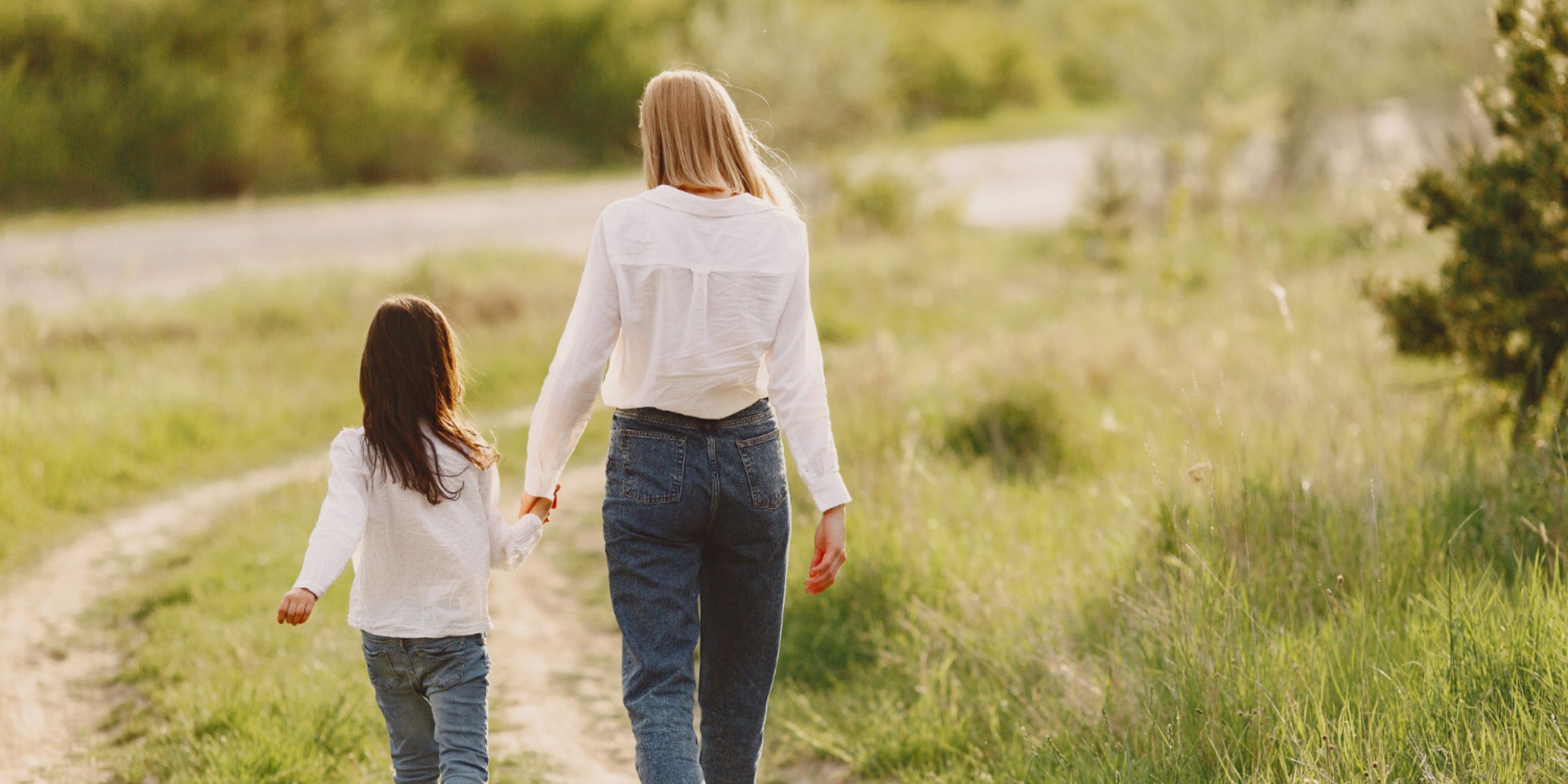 A woman and a little girl walking on a field | Source: Freepik
