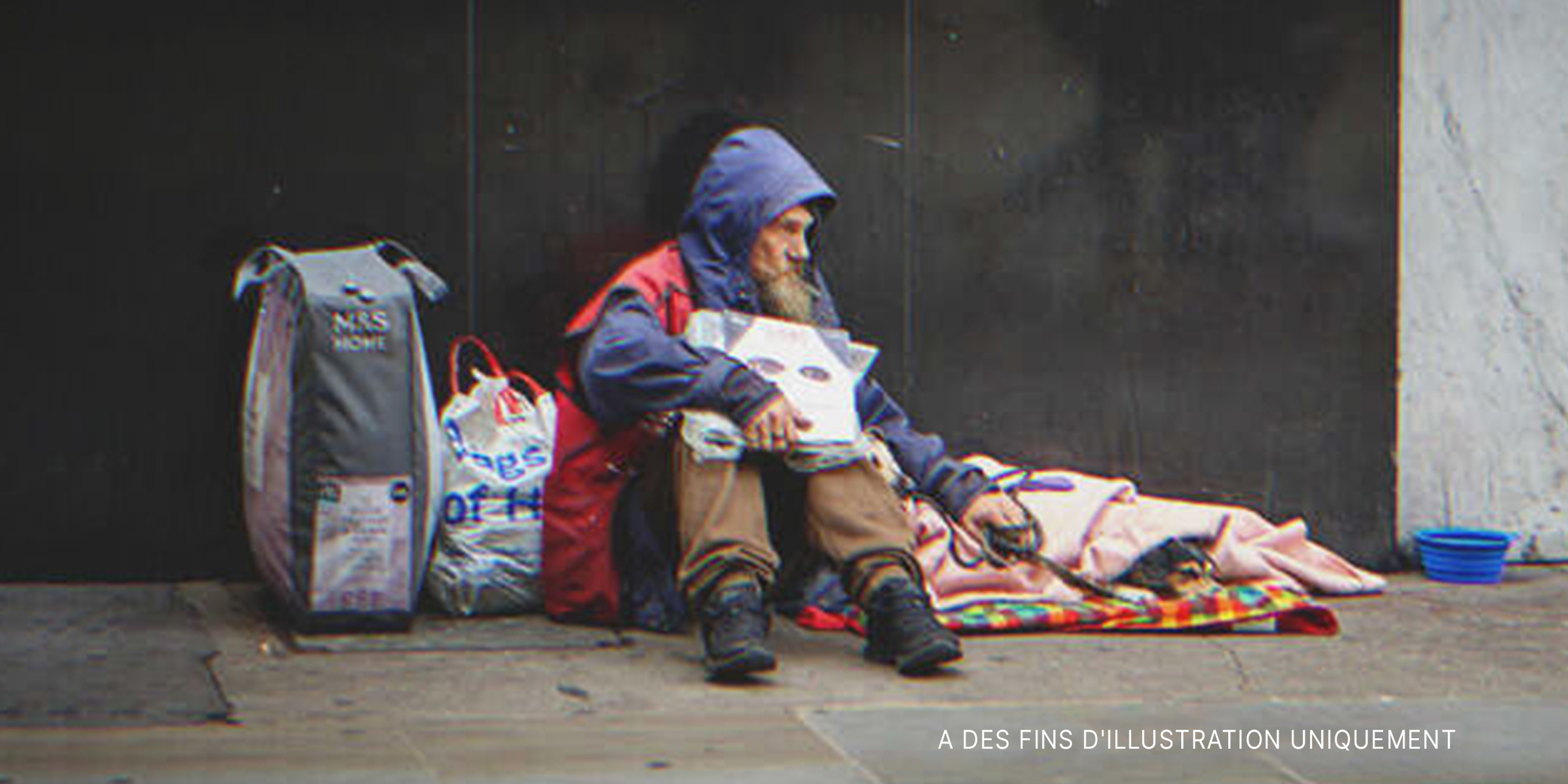 Un homme sans-abri assis sur un trottoir. | Source : Shutterstock