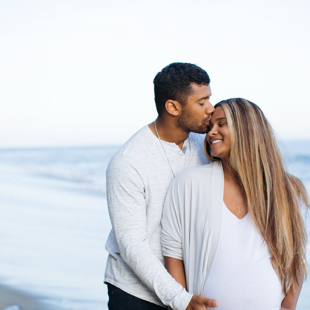 Russell Wilson kissing Ciara on the forehead as the couple shares a sweet moment at the beach. | Source: Instagram/dangerusswilson