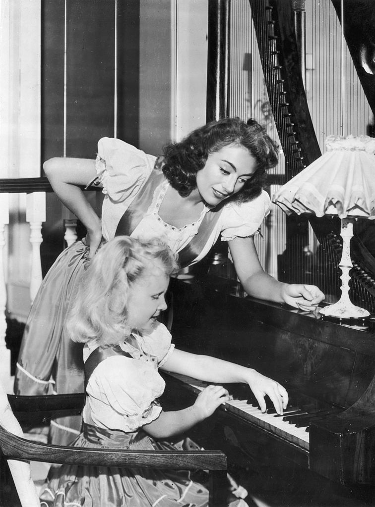 Joan Crawford y su hija Christina tocando el piano.| Fuente: Getty Images Joan Crawford y su hija Christina tocando el piano.| Fuente: Getty Images