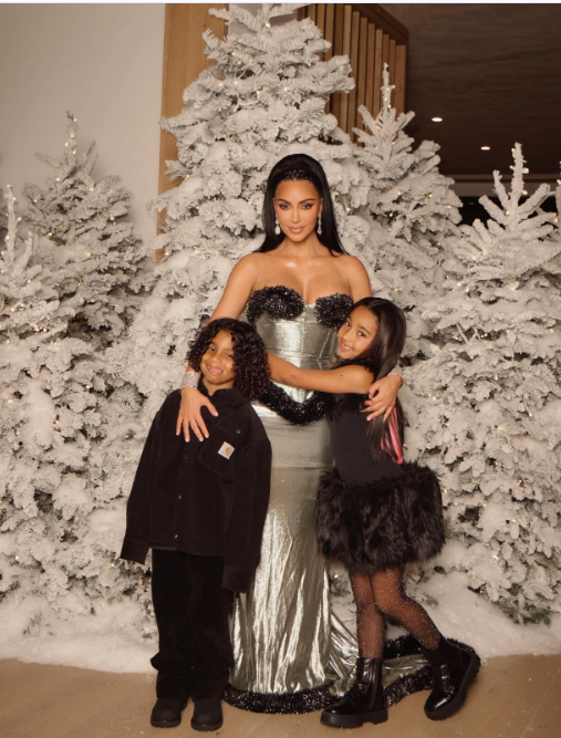 Kim Kardashian and her youngest kids Chicago and Psalm West posing in front of Christmas trees, from a post dated December 27, 2025 | Source: Instagram/kimkardashian