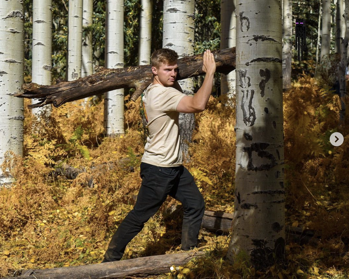 Garrison Brown carrying a branch of a tree in a photo he shared on his social media on October 13, 2020 | Source: instagram/roberththebrown