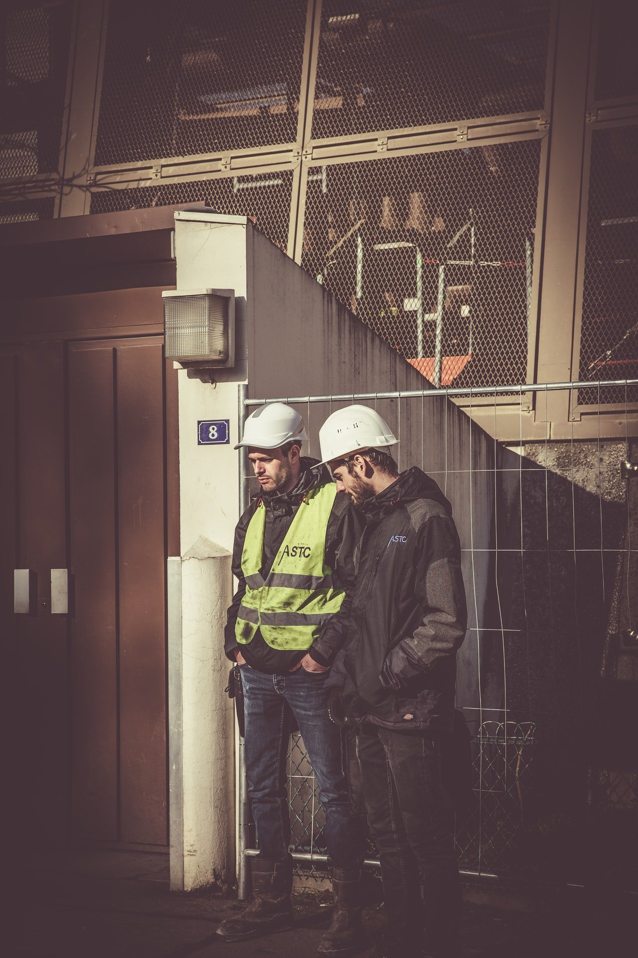 Two construction workers having a discussion | Photo: Pexels