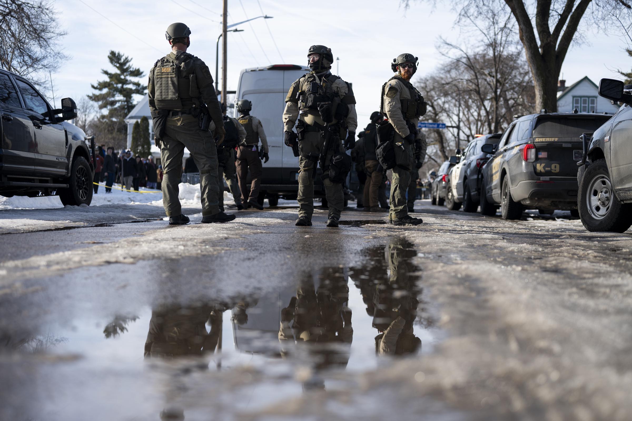 Heavily armed officers secure the area after the fatal shooting involving U.S. immigration agents in Minneapolis | Source: Getty Images