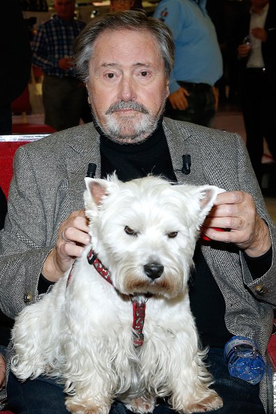 L'acteur Victor Lanoux, avec son chien Babette, présente son livre "Deux heures a tuer au bord de la piscine" . | Photo : Getty Images.