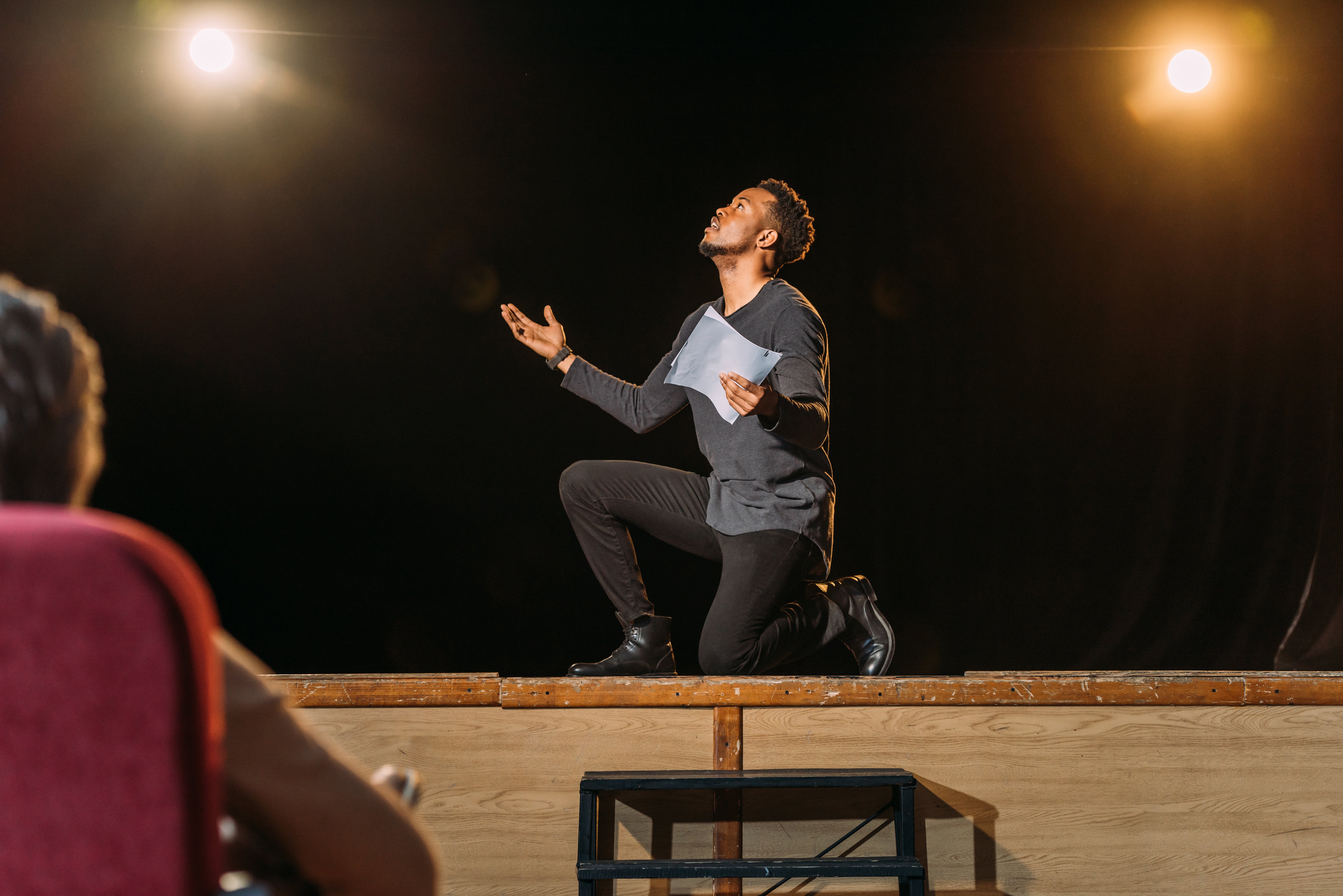 A man auditioning on stage.| Source: Shutterstock