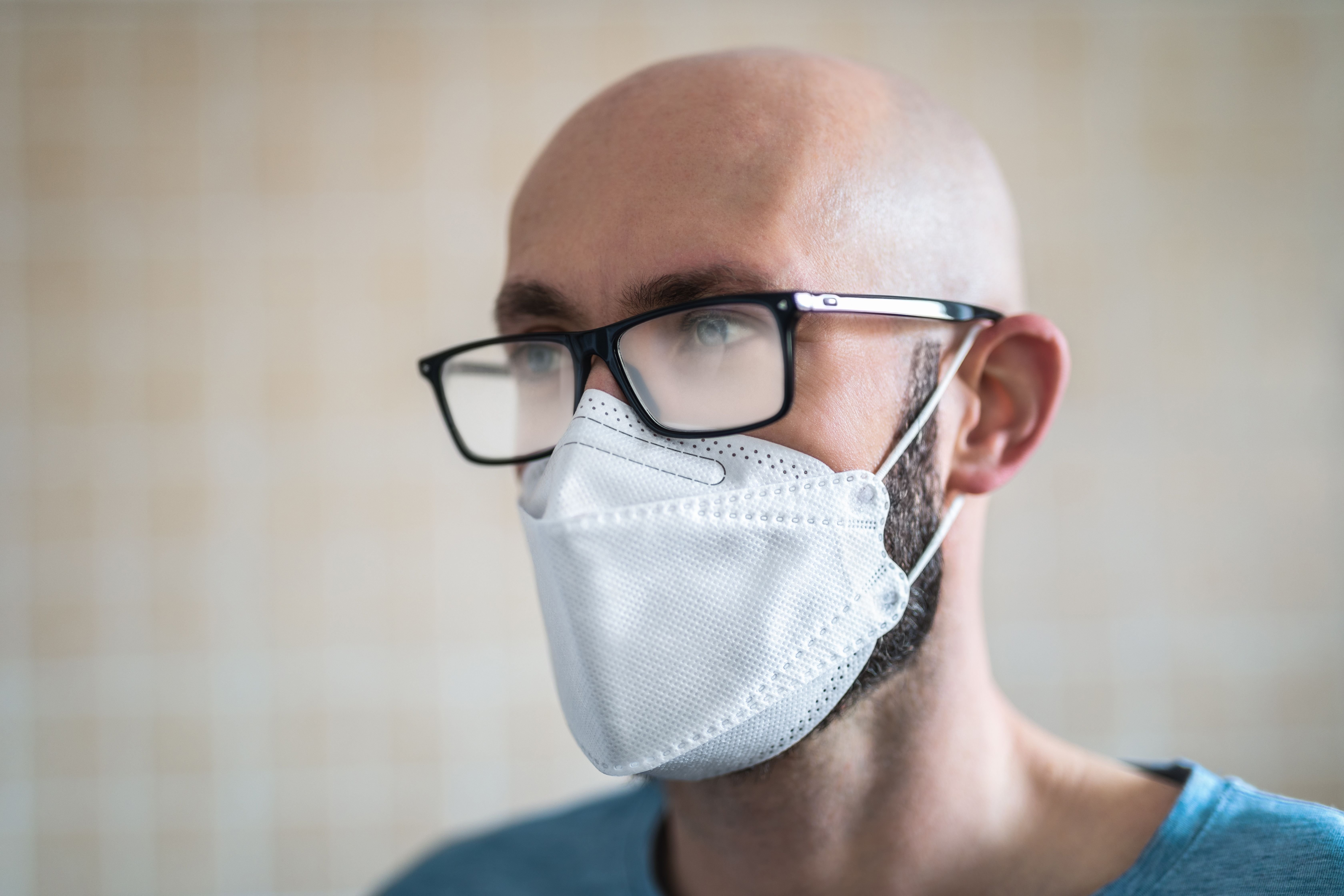 A man wearing glasses and a mask. | Source: Getty Images