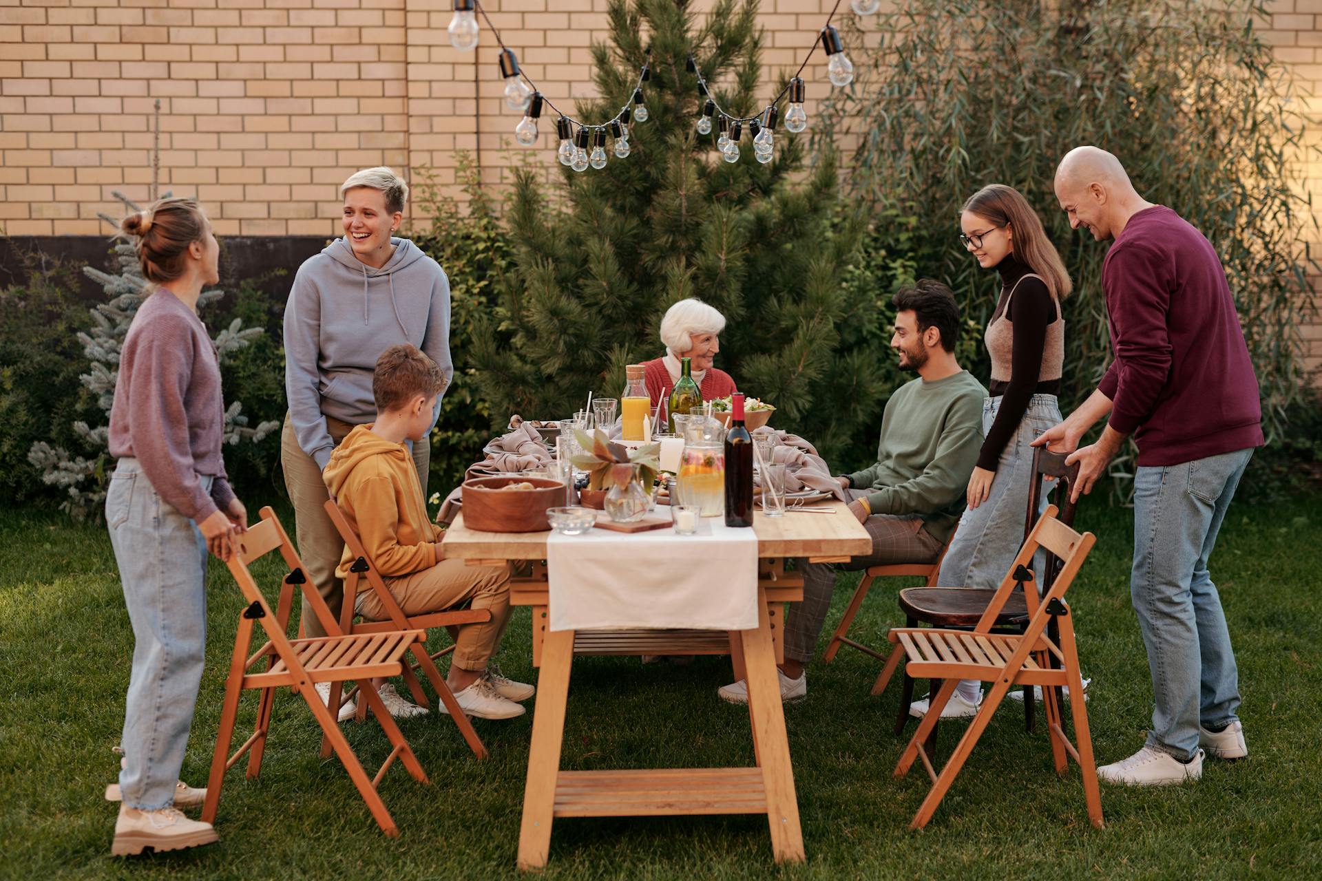 Family members gathered around the dinner table in their garden | Source: Pexels