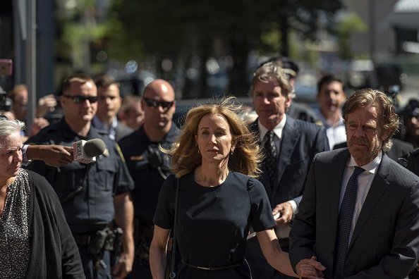 Felicity Huffman, center, arrives at federal court with her husband actor William H. Macy in Boston | Photo: Getty Images