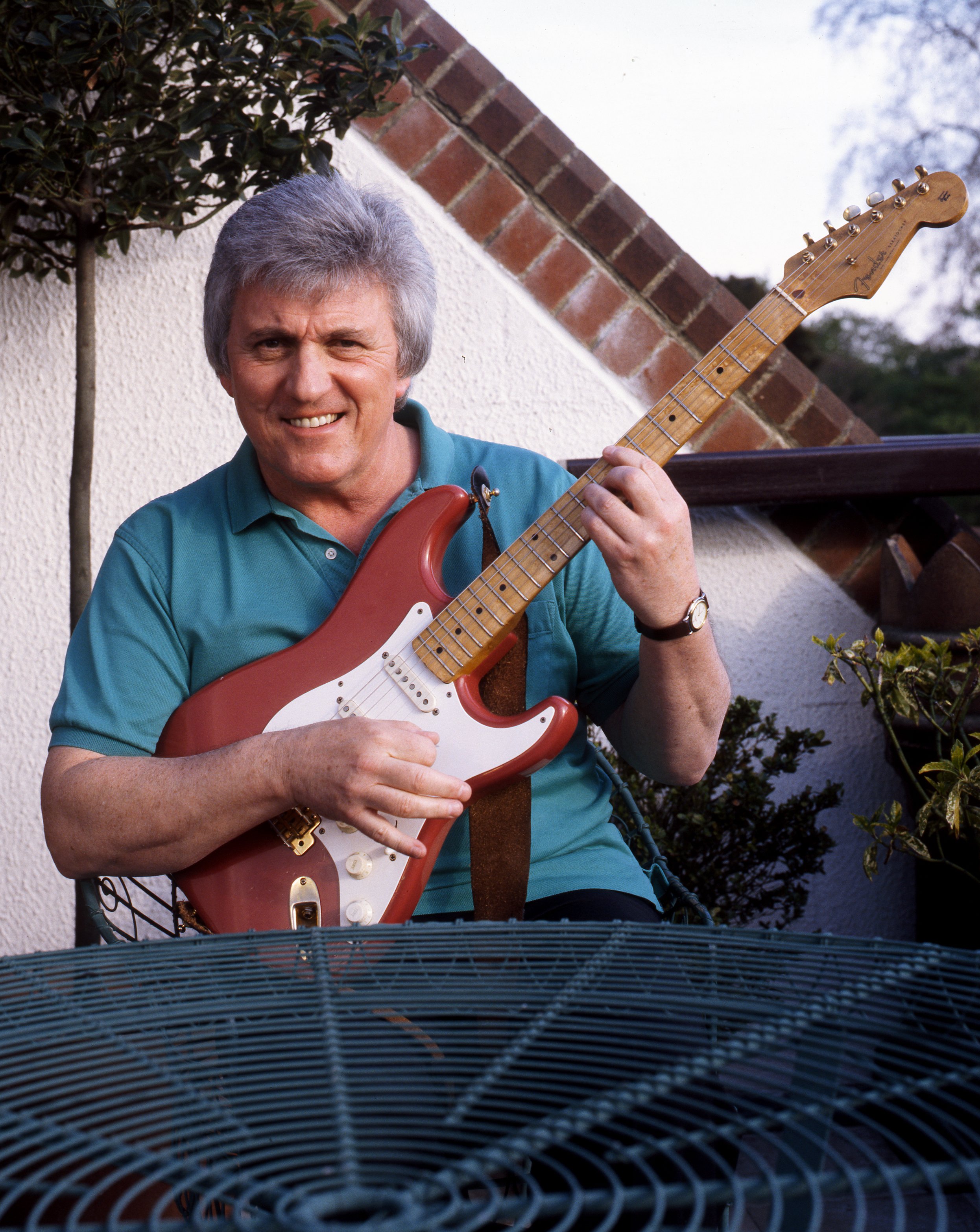 Bruce Welch holding "The Shadows" 1959 Fender Stratocaster, played by Hank Marvin and owned by Bruce Welch in the UK in 1997 | Source: Getty Images