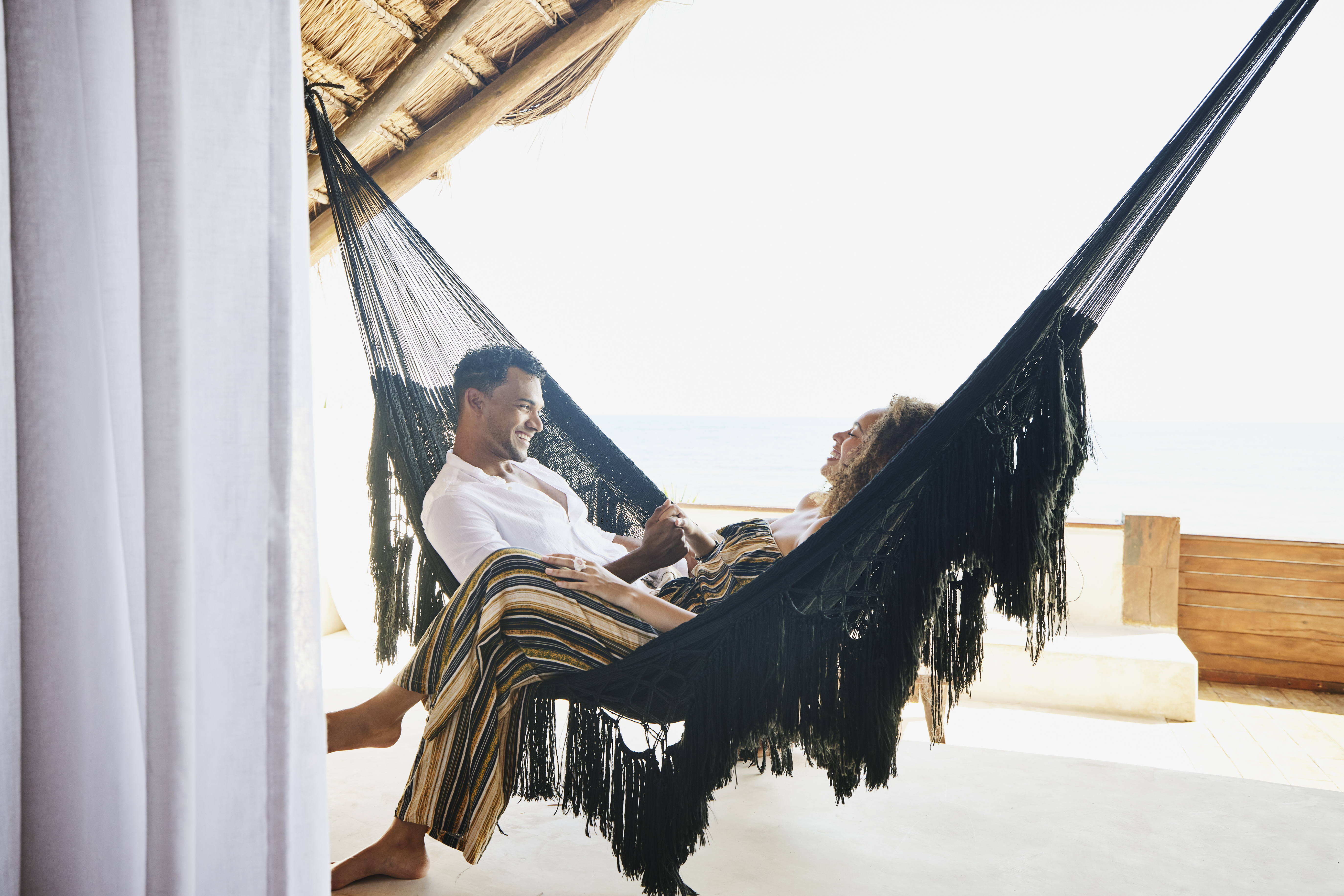 A couple enjoying their vaction while spending quality time on a hammock | Source: Getty Images