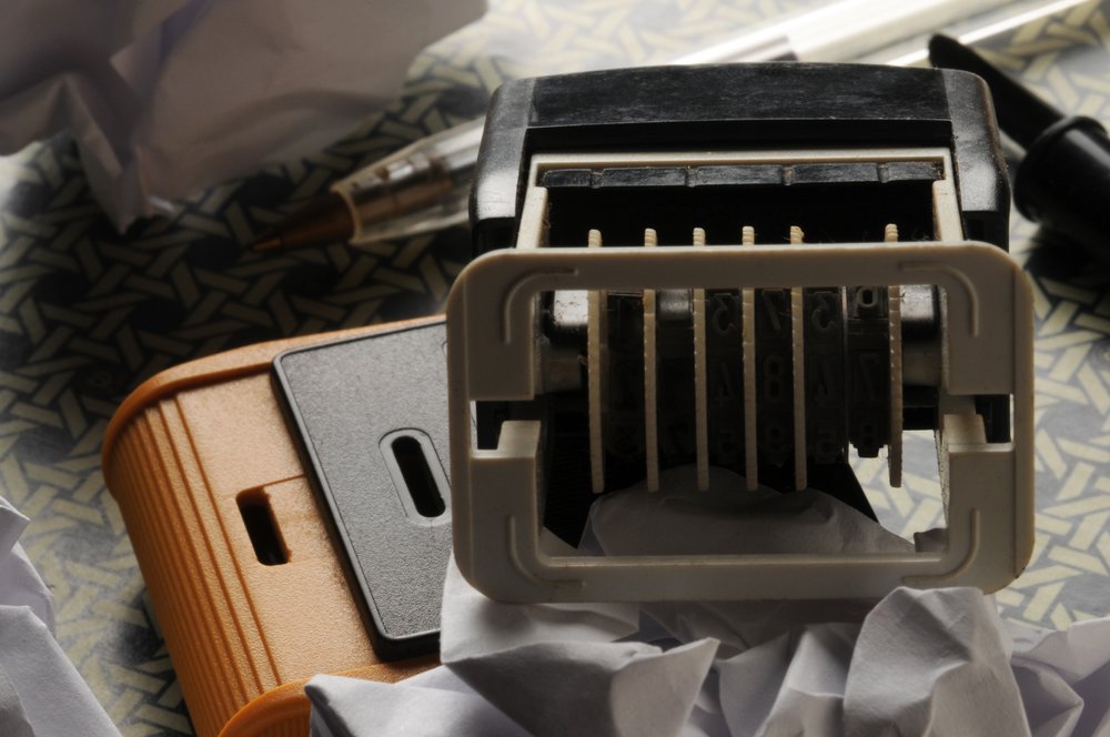 Maquinilla selladora de goma sobre varios papeles arrugados. | Foto: Shutterstock