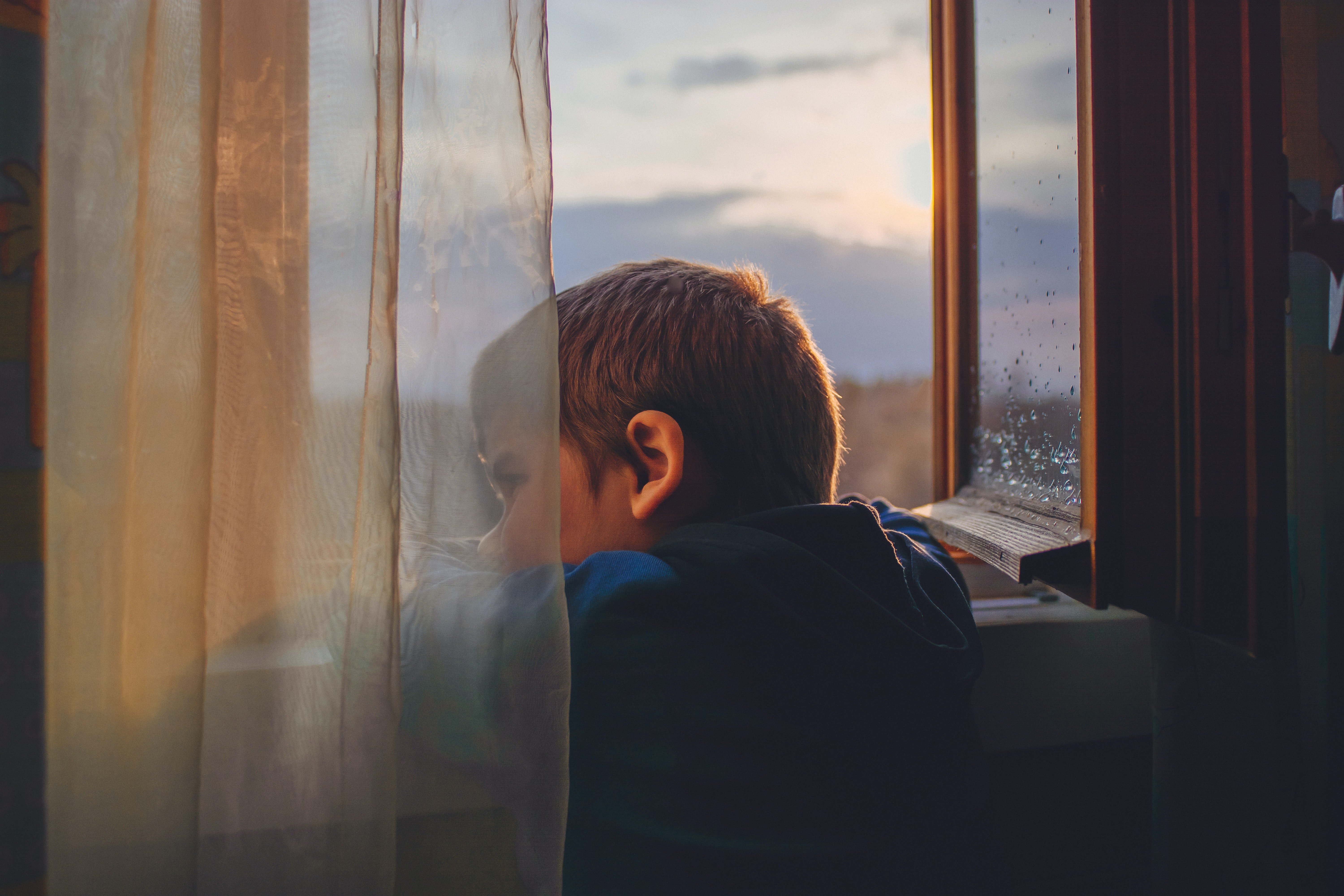 Un niño mira ansioso por la ventana. | Foto: Pexels