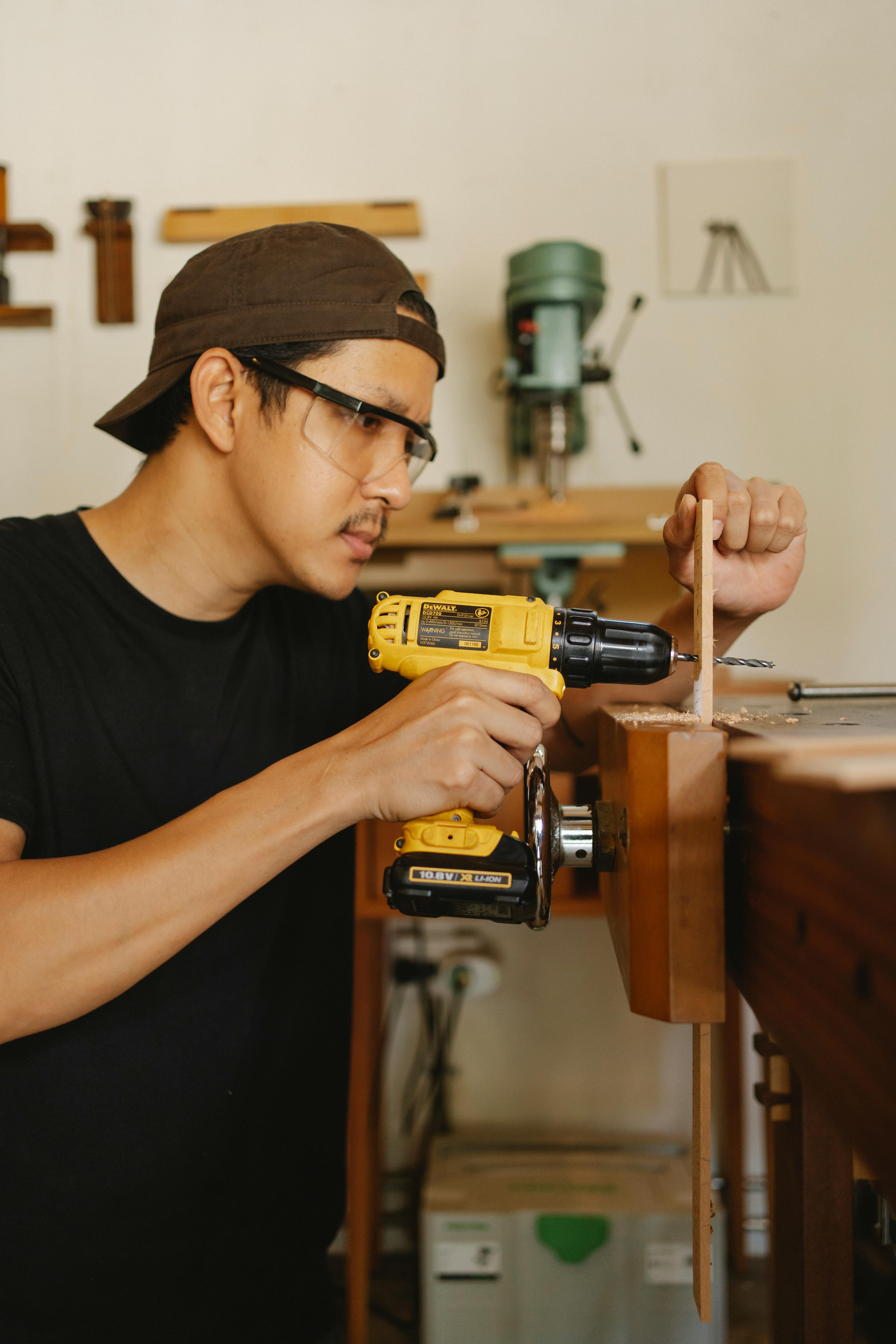 A man drilling a wooden plank | Source: Pexels