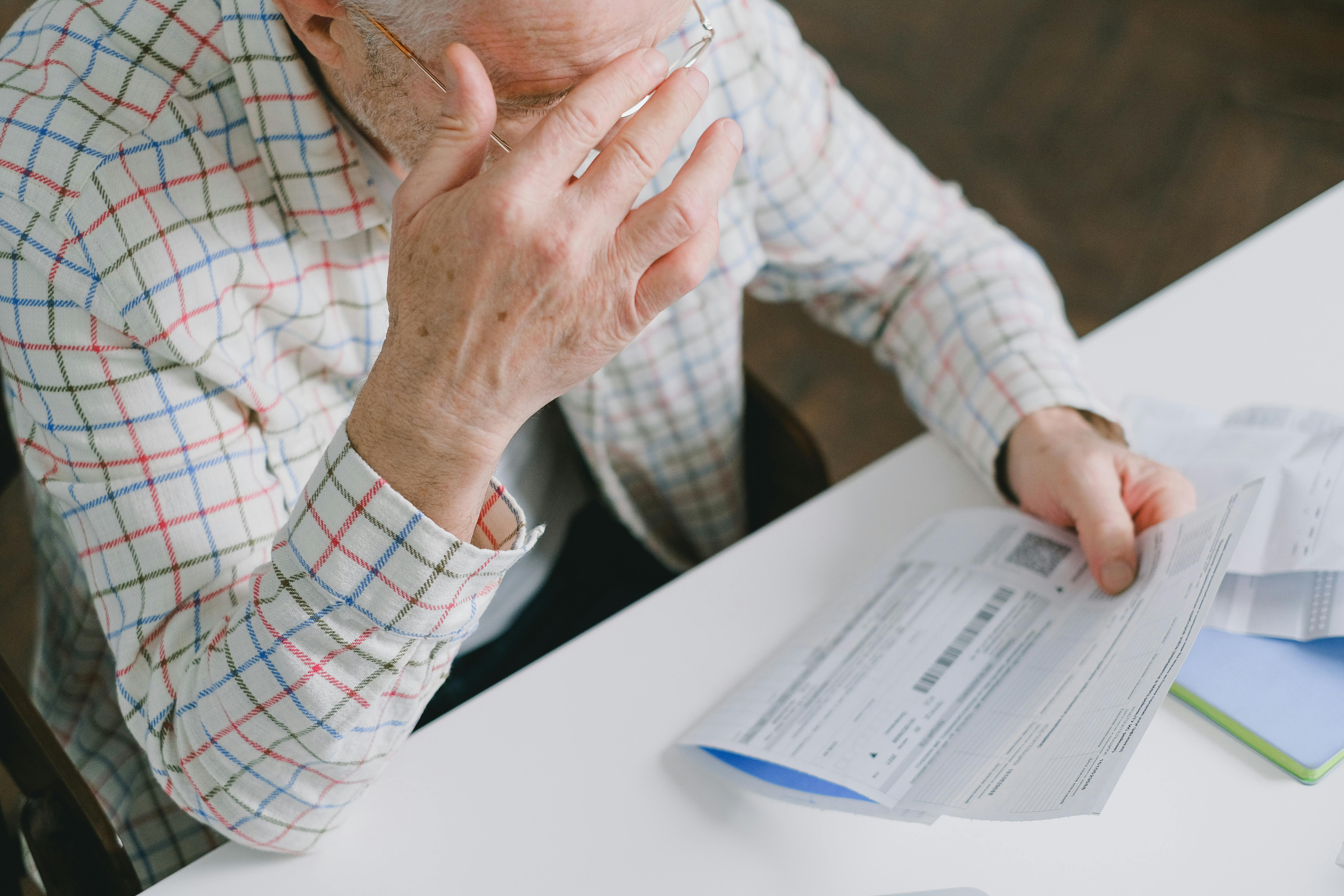 Elderly man holding a piece of paper | Source: Pexels