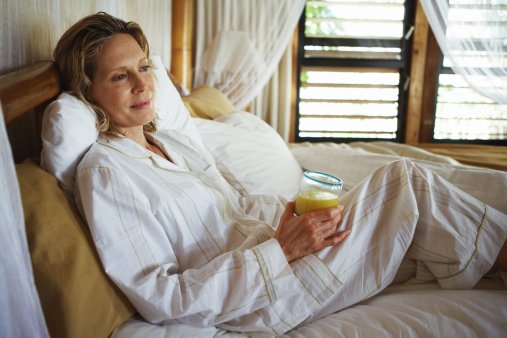Photo of woman with orange juice in bed | Photo: Getty Images