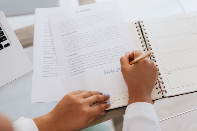 Woman signing a contract | Source: Pexels