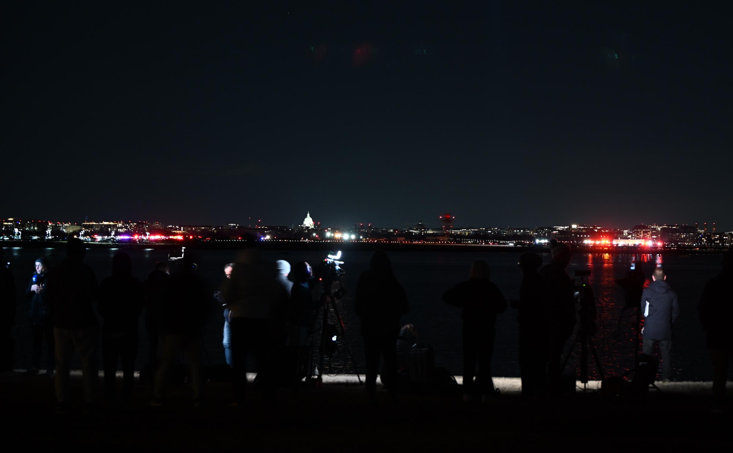 Press members near the scene area after a regional plane collided in midair with a military helicopter and crashed into the Potomac River in Washington, D.C. on January 30, 2025. | Source: Getty Images