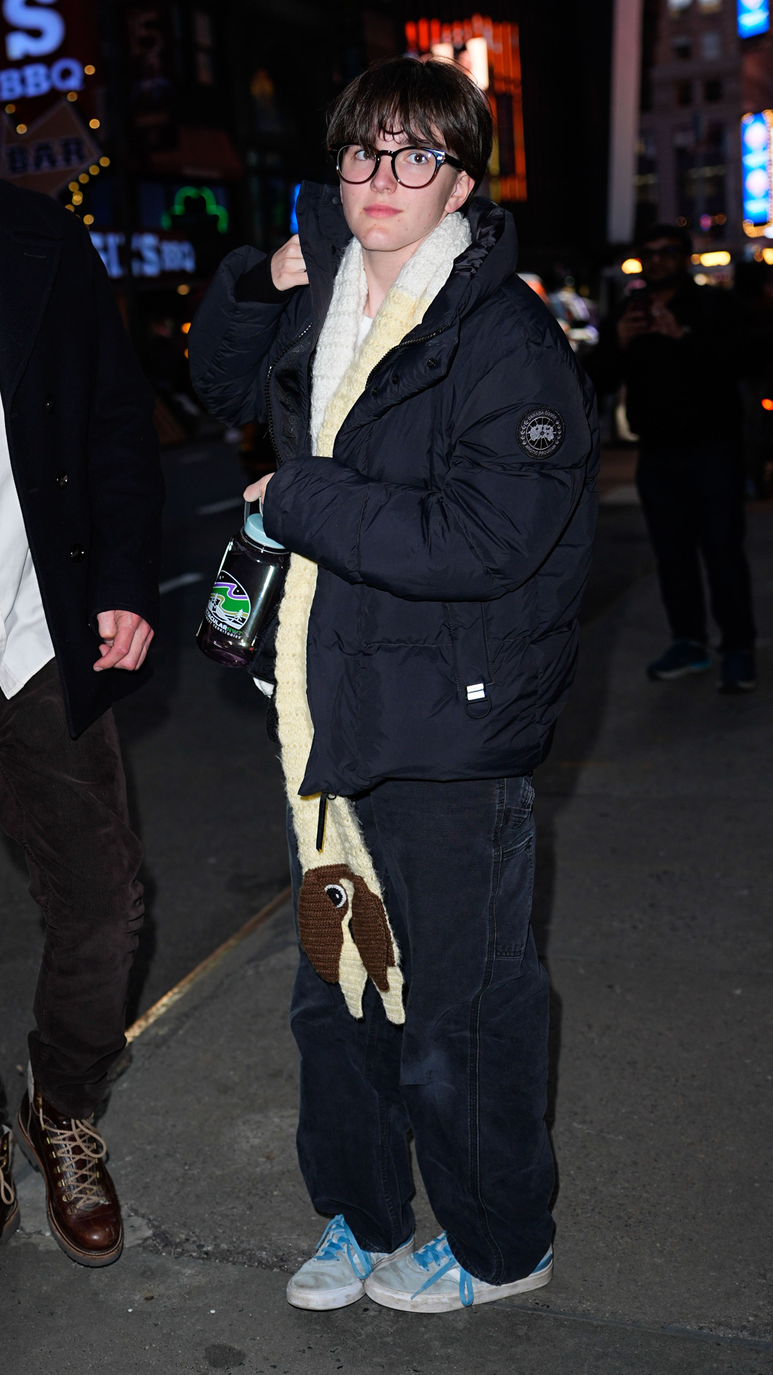 Fin stepped out in an oversized puffer jacket, loose-fitting jeans, and large-framed glasses during an evening outing. The layered look marked another evolution from the brightly colored buzz-cut era seen two years earlier. | Source: Getty Images