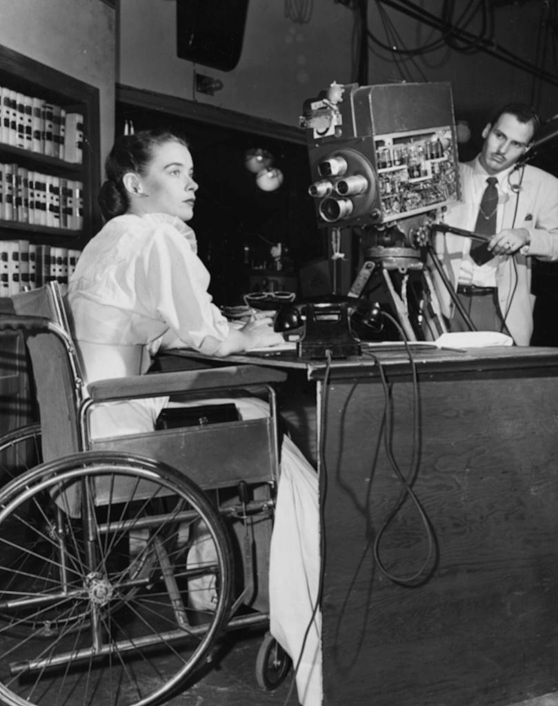Actress Susan Peters sitting behind a desk in her wheelchair, in front of a WPTZ television camera filming her show "Miss Susan" circa 1951.  | Source: Getty Images