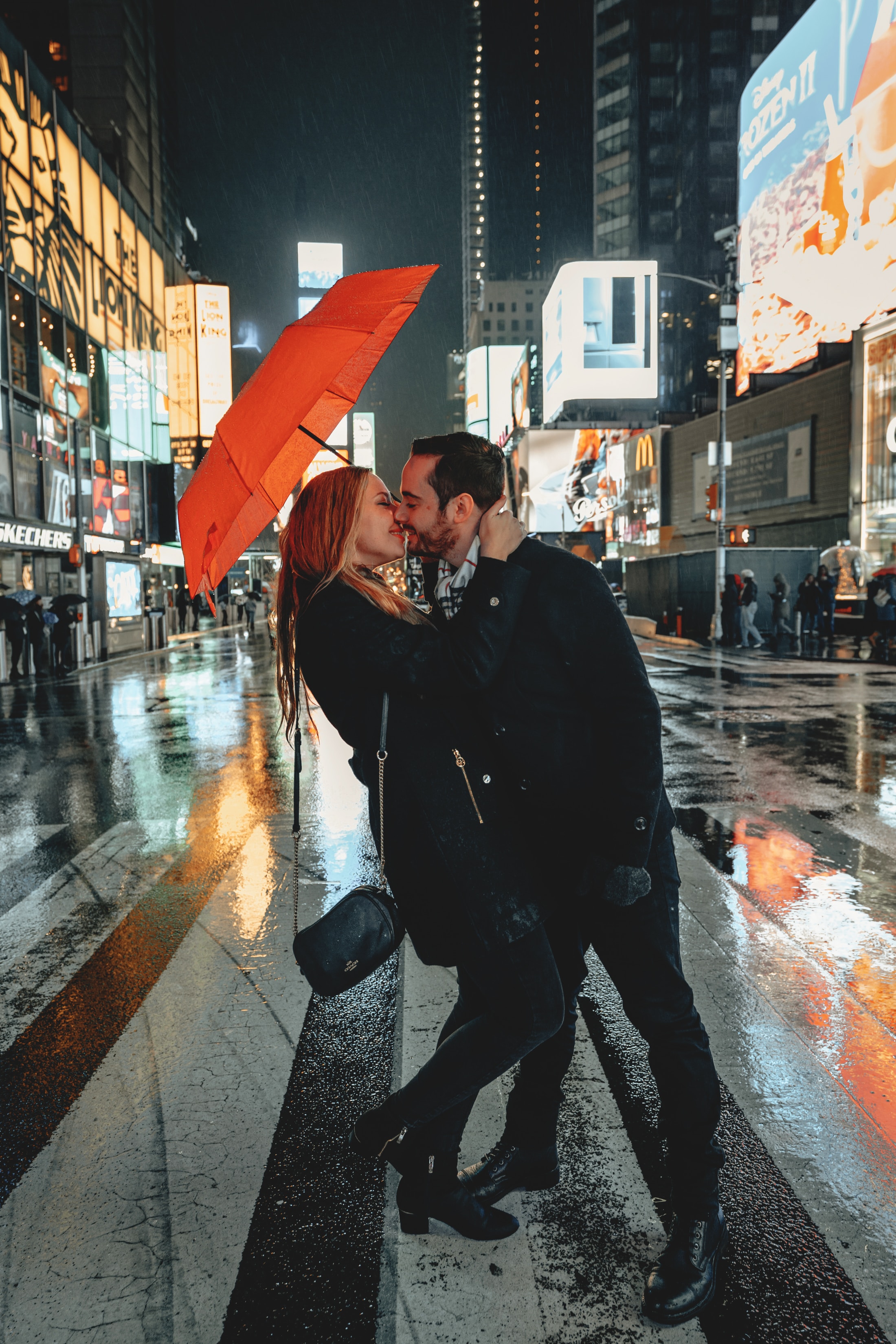 A couple kissing under an umbrella in Times Square. | Source: Unsplash