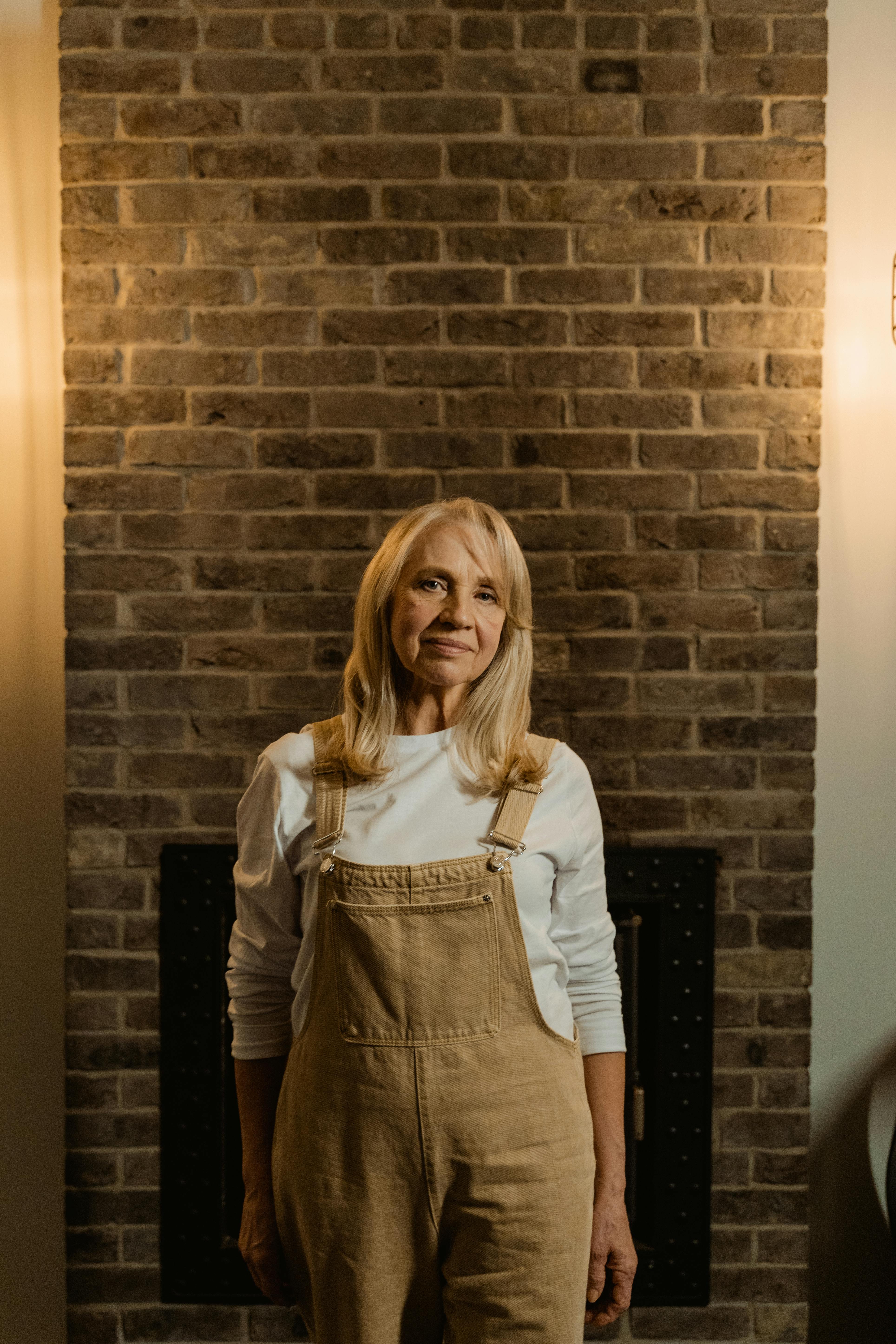 A woman standing beside a brick wall  | Source: Pexels