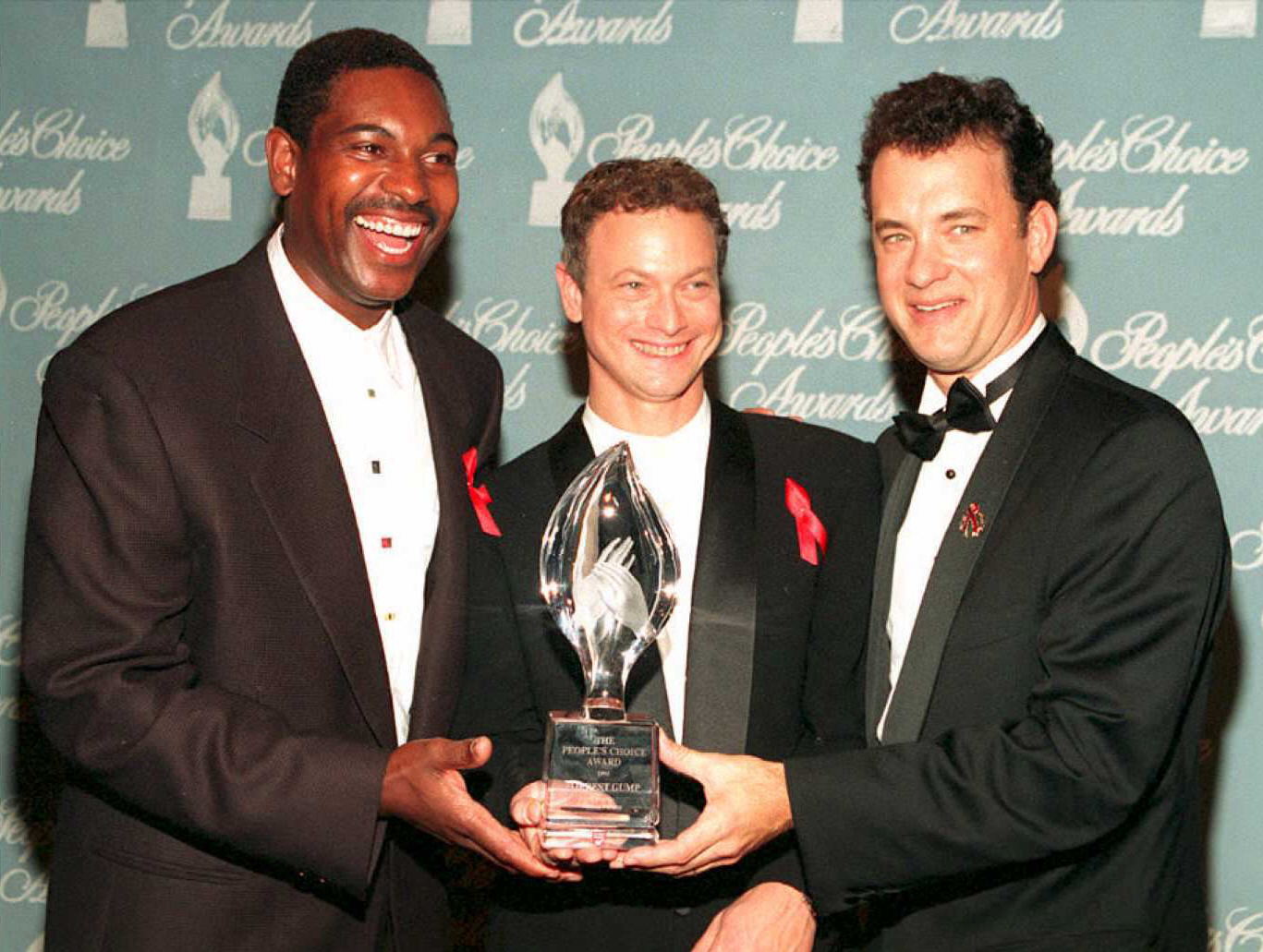 Mykelti Williamson, Gary Sinise, and Tom Hanks from the movie "Forrest Gump" pose with the award they won during the 21st Annual People's Choice Awards at Universal City Studios | Source: Getty Images